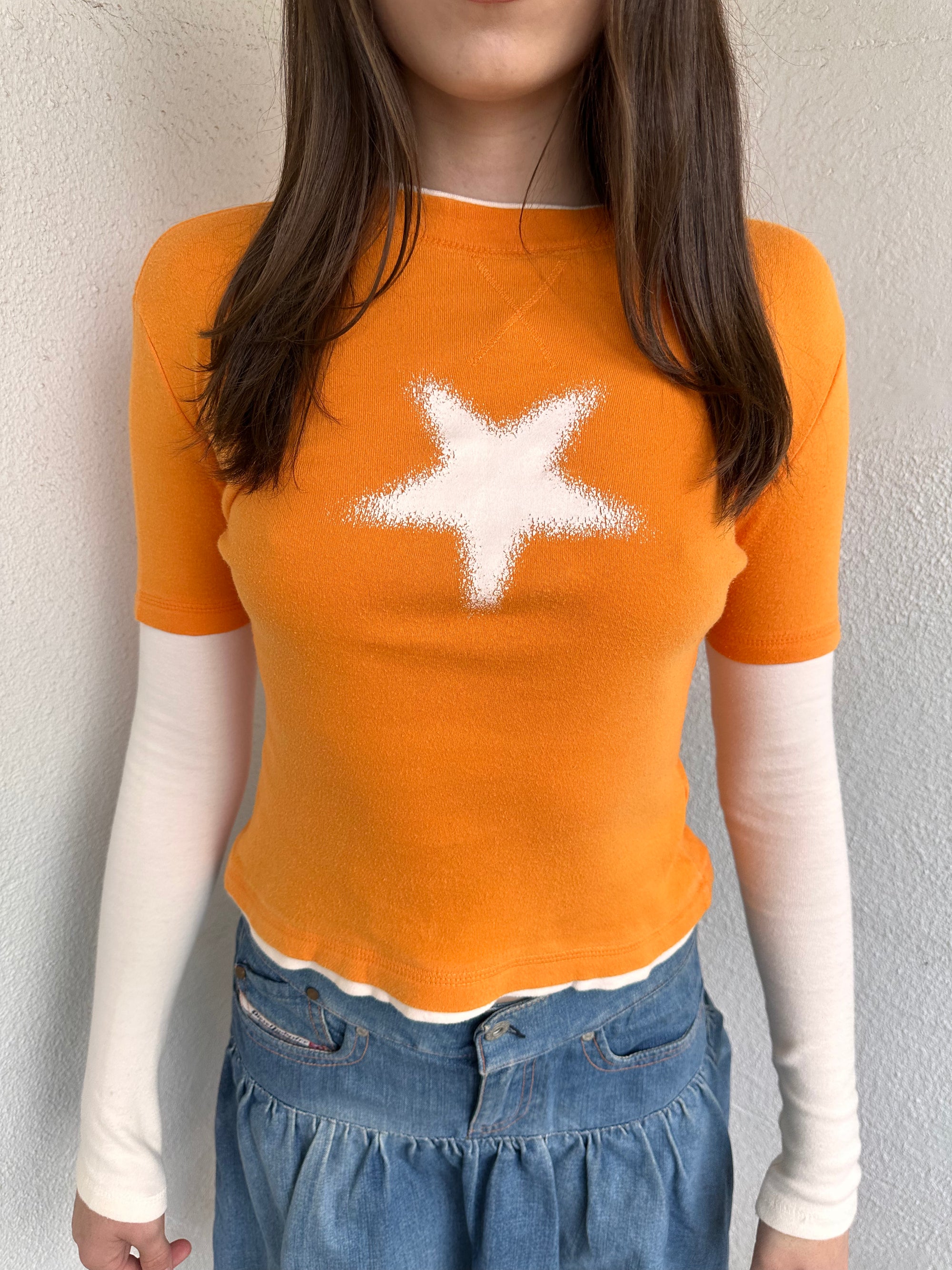 Woman wearing a Y2K 00s Y2K Orange star layered long sleeve top.
