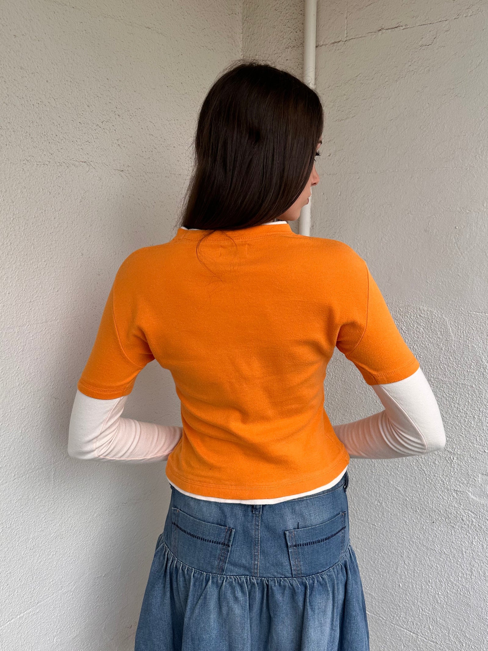 Woman wearing a Y2K 00s Y2K Orange star layered long sleeve top.