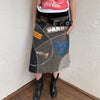 Woman wearing a Y2K 00s grey patchwork midi skirt featuring a bold, multi-coloured print design.
