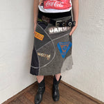 Woman wearing a Y2K 00s grey patchwork midi skirt featuring a bold, multi-coloured print design.
