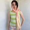 Woman Dressed in Y2K Peach and gold patterned festival scarf featuring a sheer silk-style fabric with a small circular pattern and gold fleck detailing throughout.