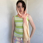 Woman Dressed in Y2K Peach and gold patterned festival scarf featuring a sheer silk-style fabric with a small circular pattern and gold fleck detailing throughout.