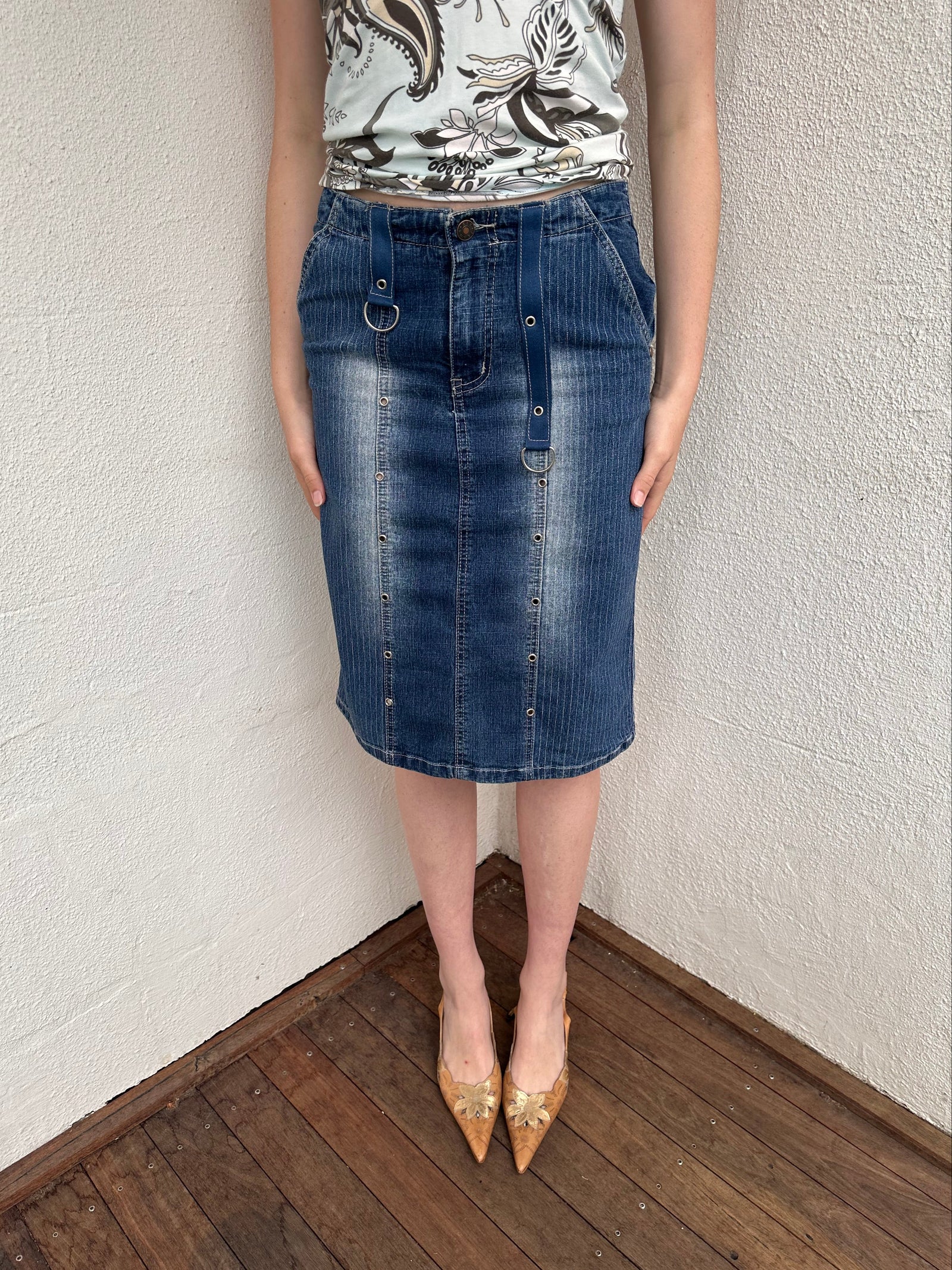 Woman wearing a Y2K 00s Pinstripe denim midi skirt featuring silver D-rings and grommet detailing across the front.