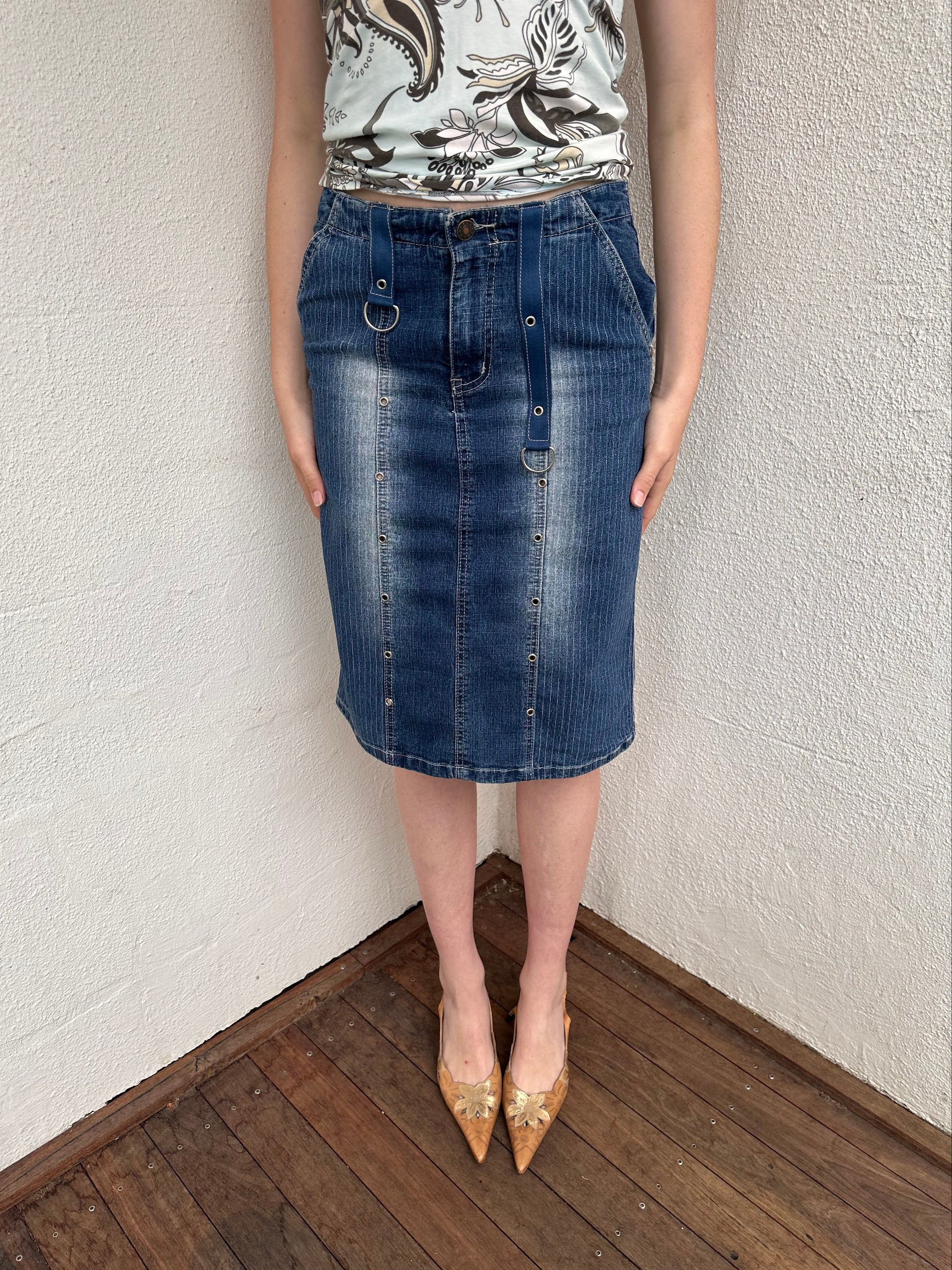 Woman wearing a Y2K 00s Pinstripe denim midi skirt featuring silver D-rings and grommet detailing across the front.