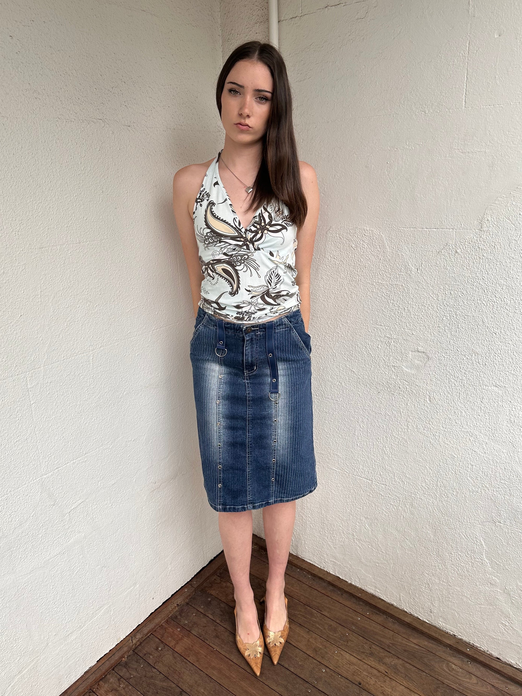 Woman wearing a Y2K 00s Pinstripe denim midi skirt featuring silver D-rings and grommet detailing across the front.