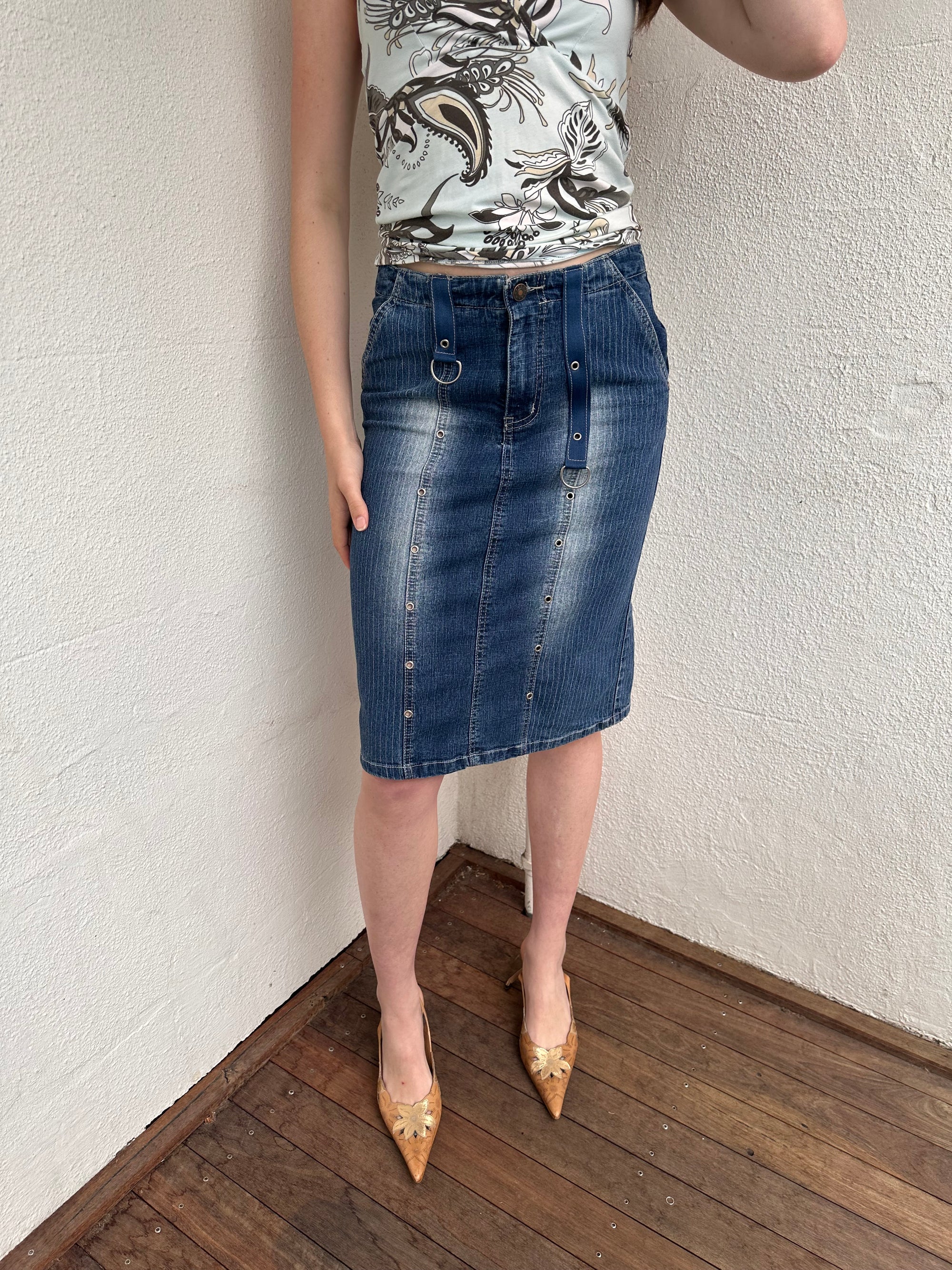 Woman wearing a Y2K 00s Pinstripe denim midi skirt featuring silver D-rings and grommet detailing across the front.