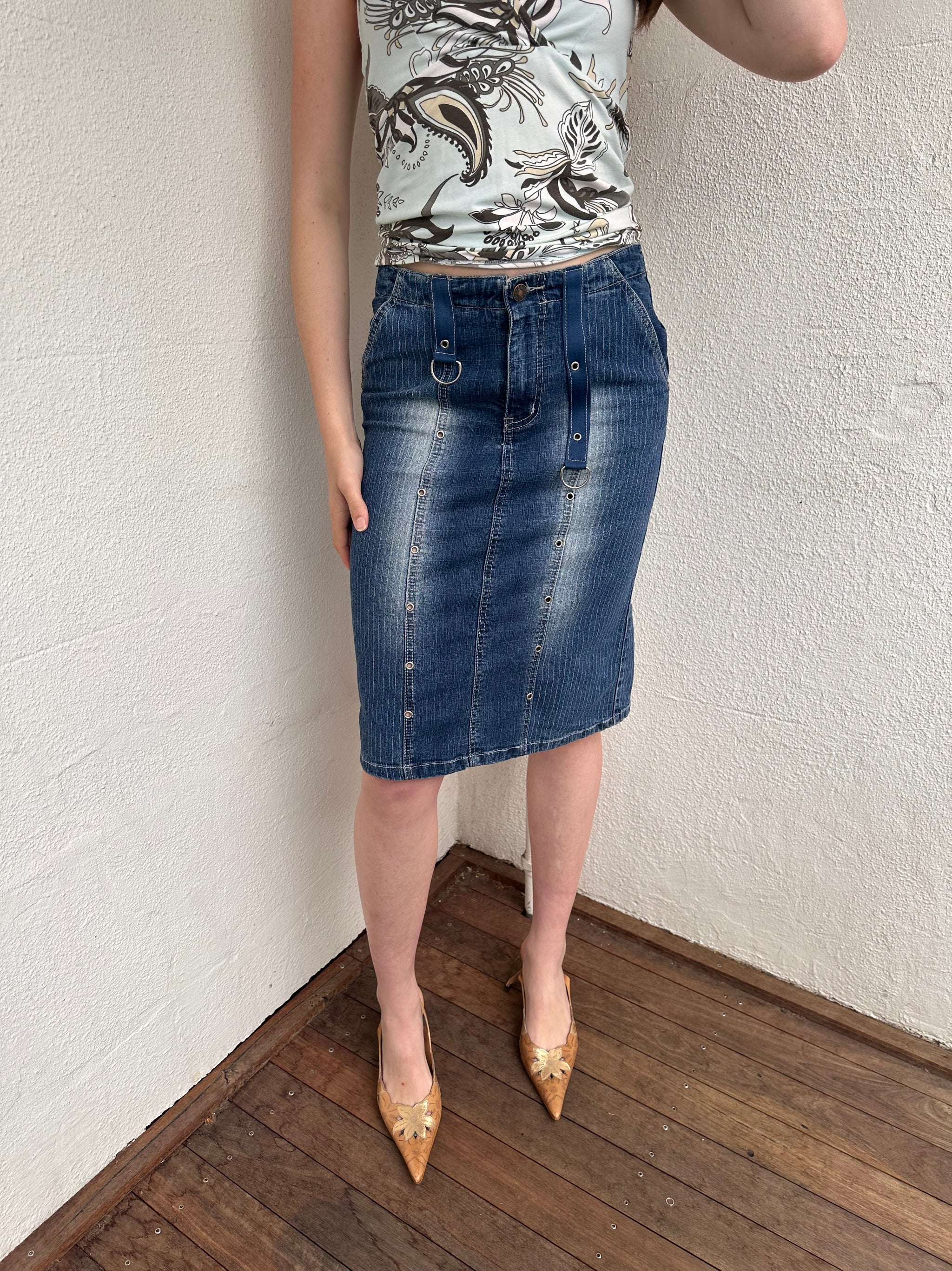 Woman wearing a Y2K 00s Pinstripe denim midi skirt featuring silver D-rings and grommet detailing across the front.