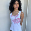 Woman wearing a Y2K 00s Hot pink flower print on white tank top features a vibrant floral graphic