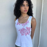 Woman wearing a Y2K 00s Hot pink flower print on white tank top features a vibrant floral graphic