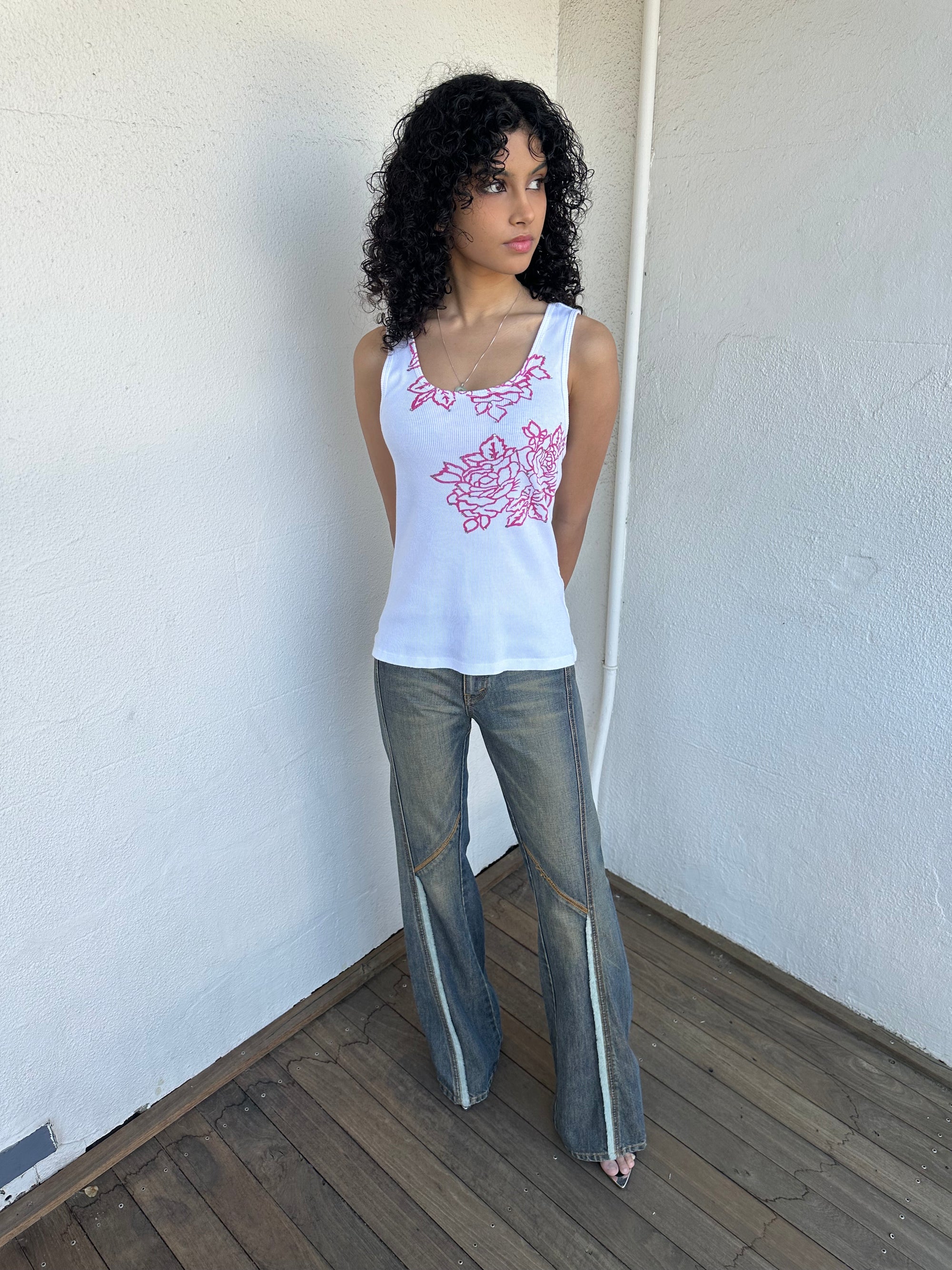 Woman wearing a Y2K 00s Hot pink flower print on white tank top features a vibrant floral graphic