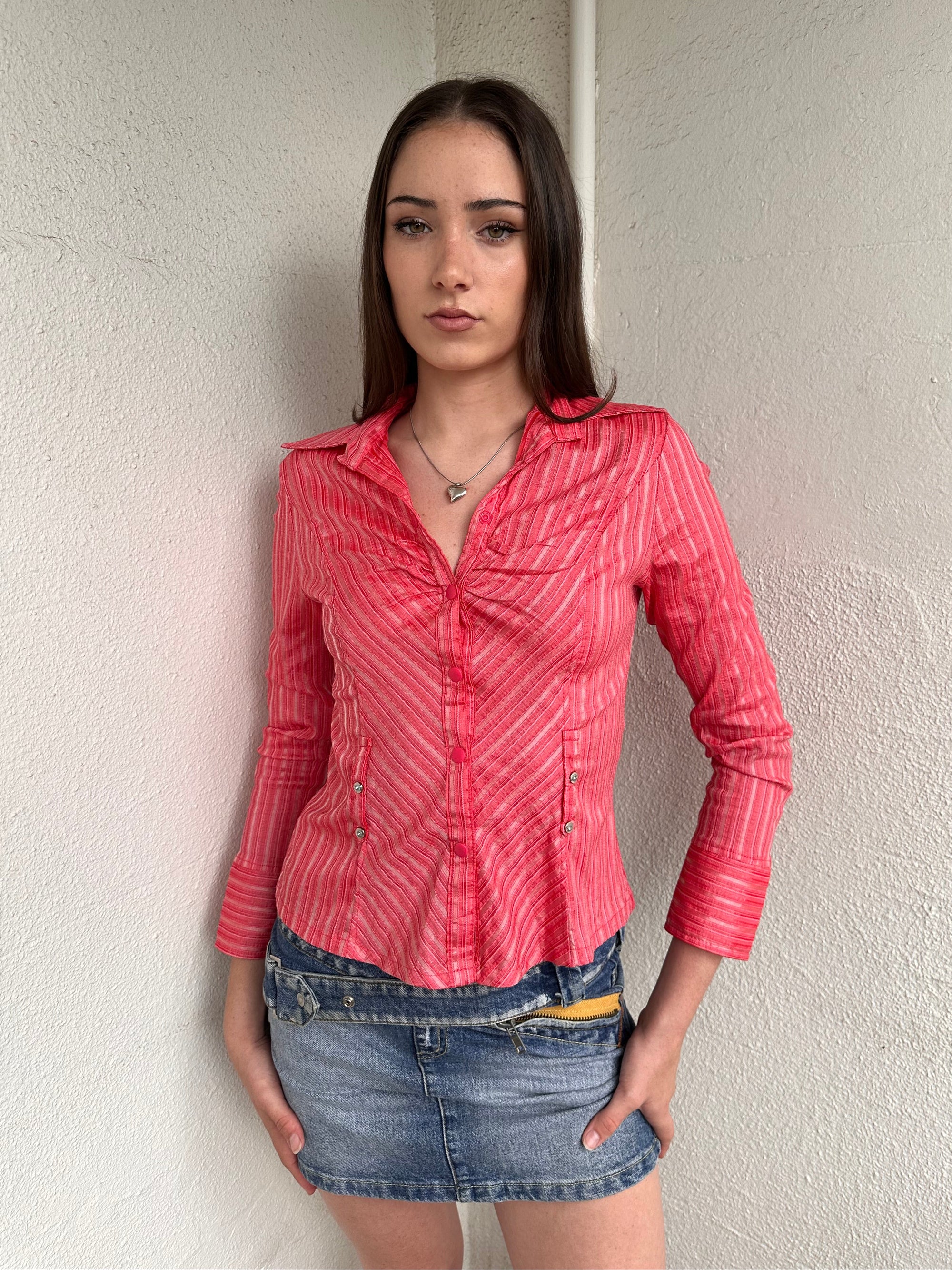 Woman wearing a Y2K 00s Pink pinstripe fitted shirt with a tailored silhouette and with a subtle shimmer to it.