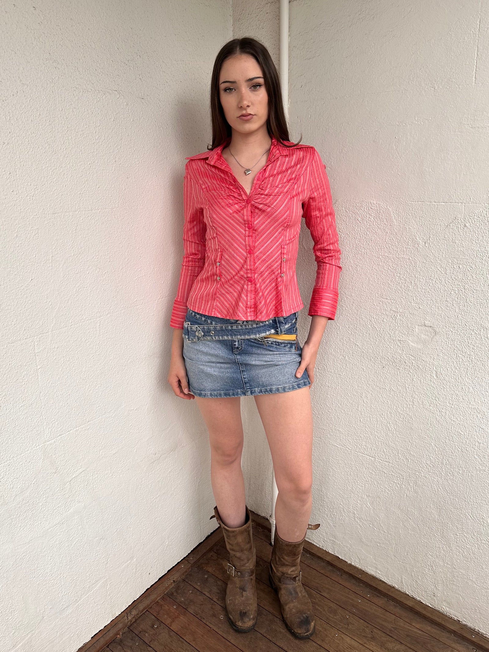 Woman wearing a Y2K 00s Pink pinstripe fitted shirt with a tailored silhouette and with a subtle shimmer to it.