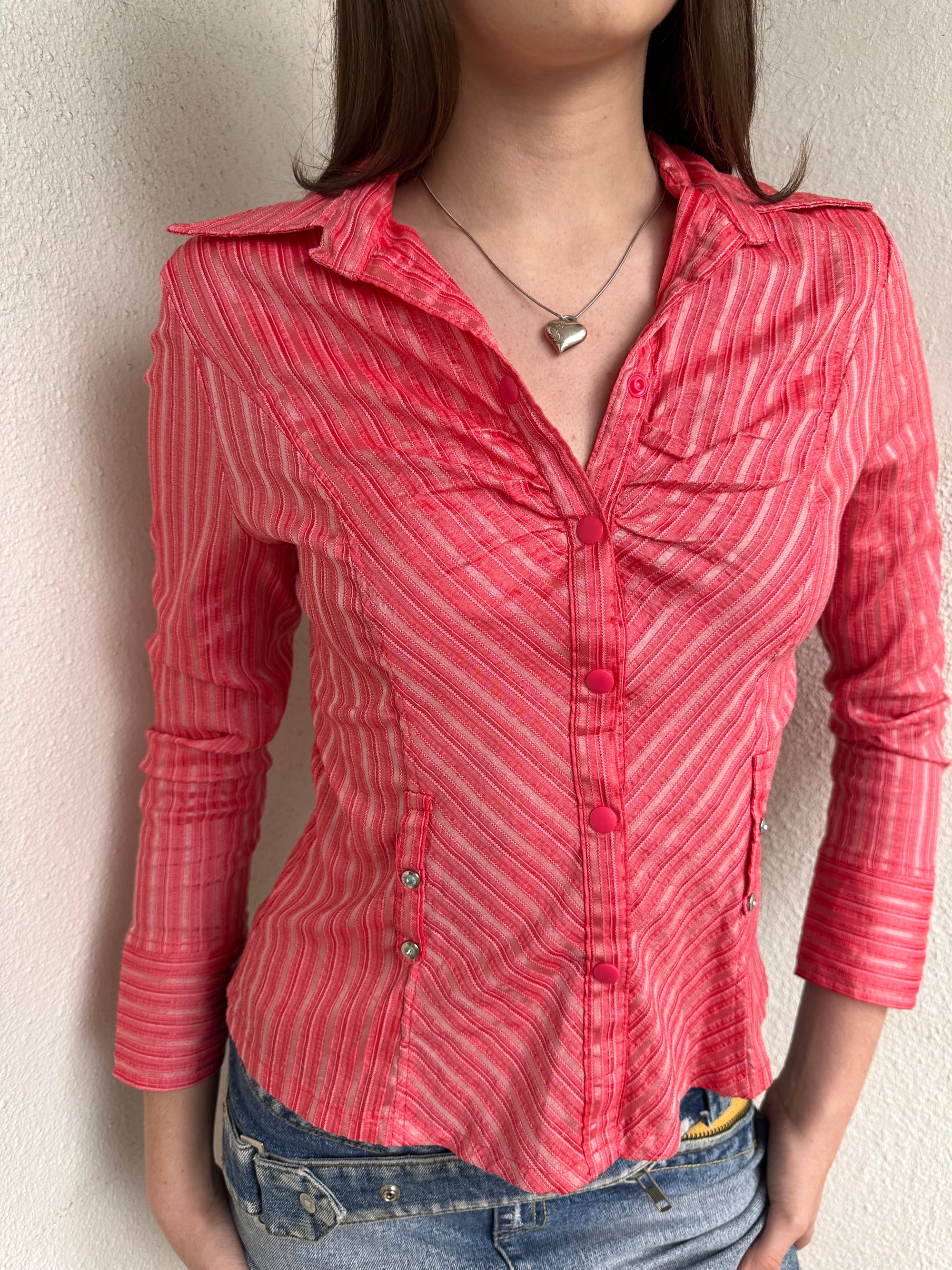 Woman wearing a Y2K 00s Pink pinstripe fitted shirt with a tailored silhouette and with a subtle shimmer to it.
