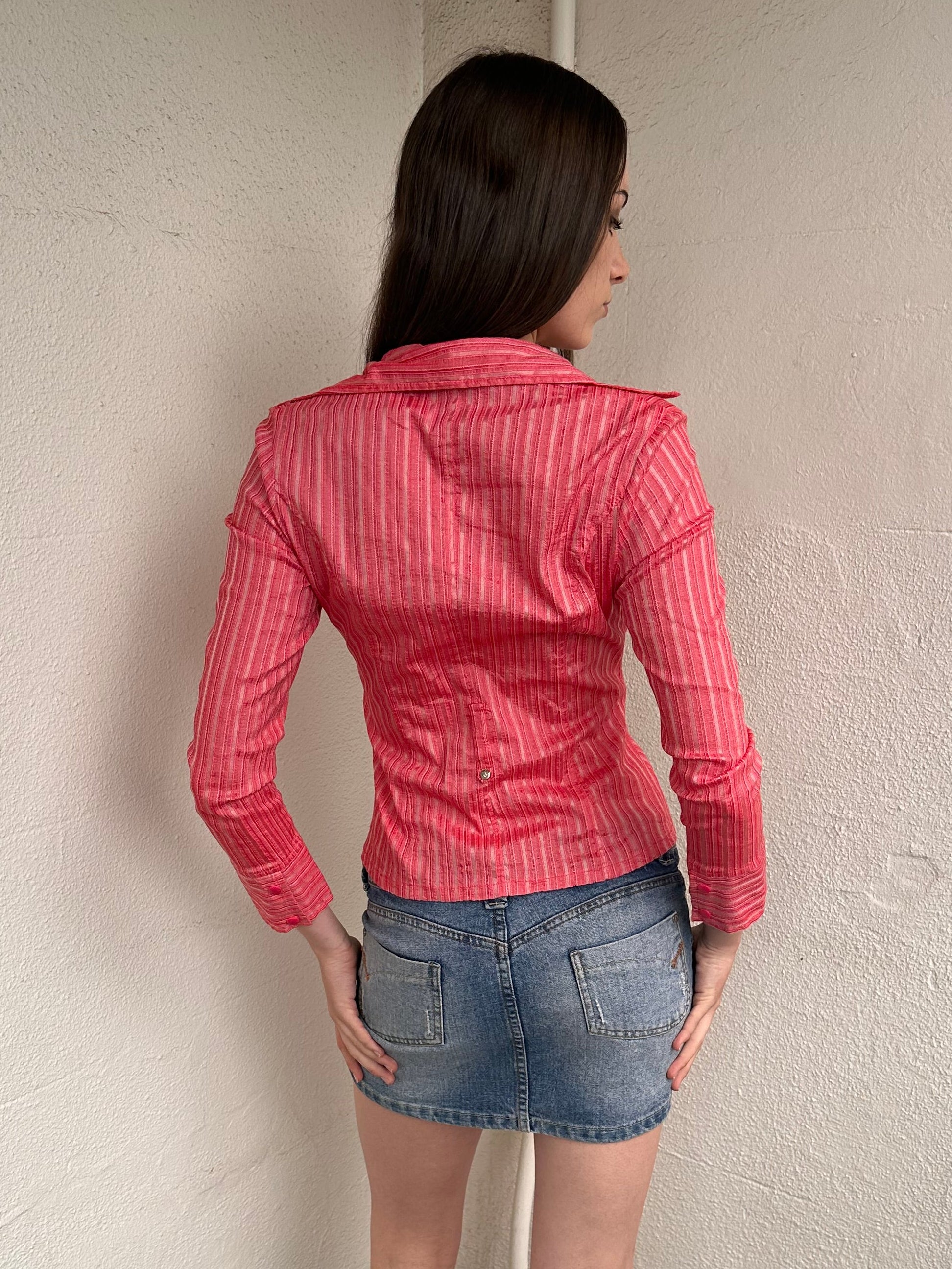 Woman wearing a Y2K 00s Pink pinstripe fitted shirt with a tailored silhouette and with a subtle shimmer to it.