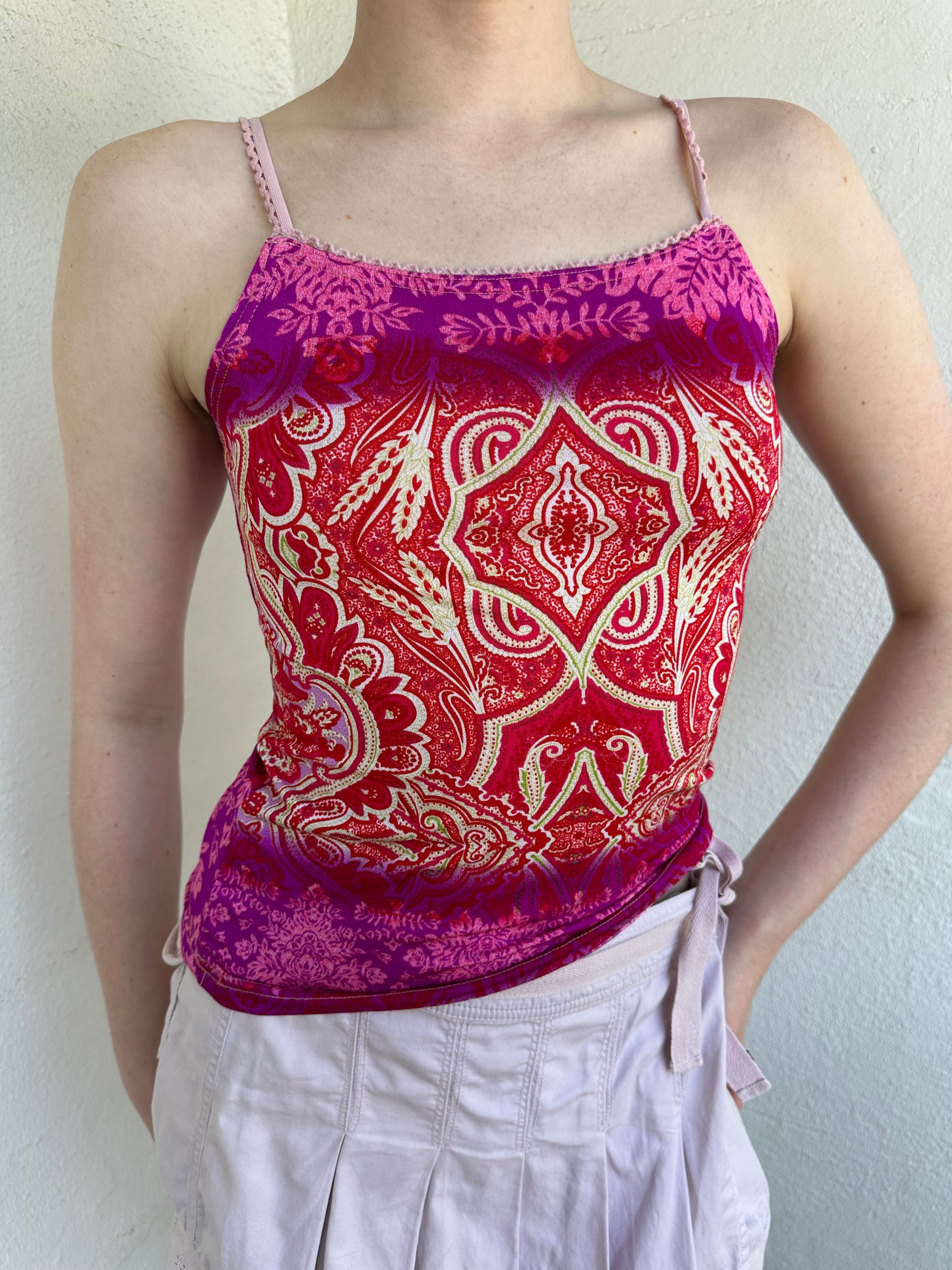 Woman Dressed in Y2K Pink and red patterned cami top featuring a red, pink, and cream mixed paisley and floral-style pattern.