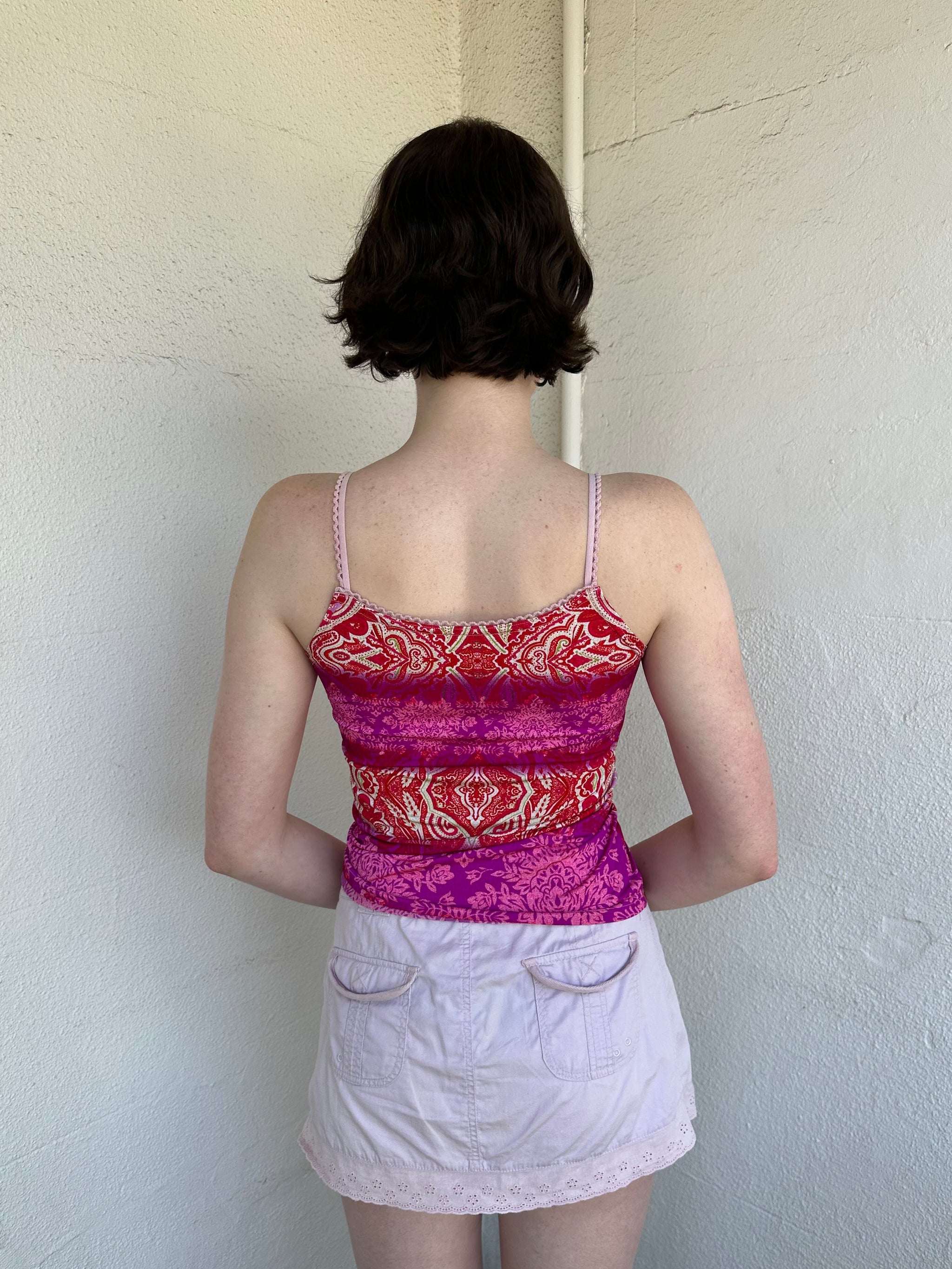 Woman Dressed in Y2K Pink and red patterned cami top featuring a red, pink, and cream mixed paisley and floral-style pattern.