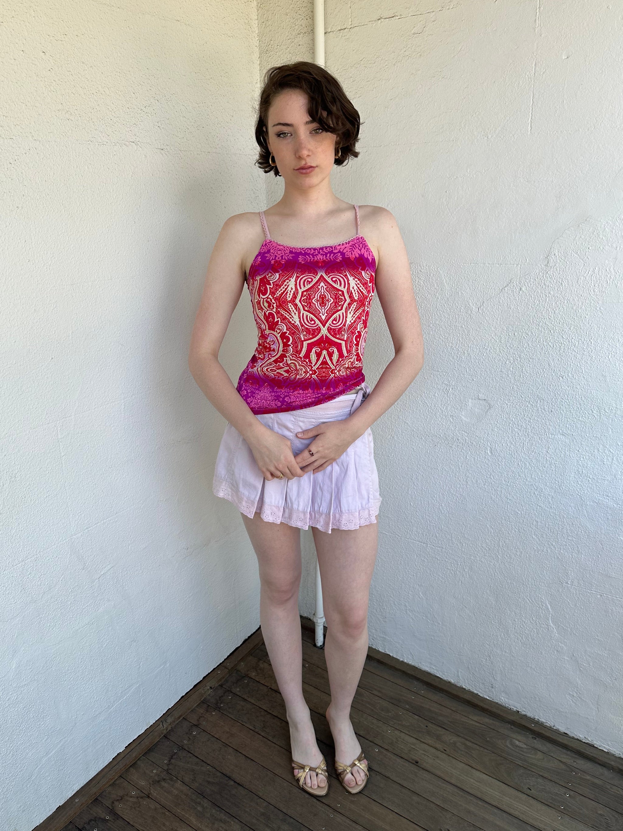 Woman Dressed in Y2K Pink and red patterned cami top featuring a red, pink, and cream mixed paisley and floral-style pattern.