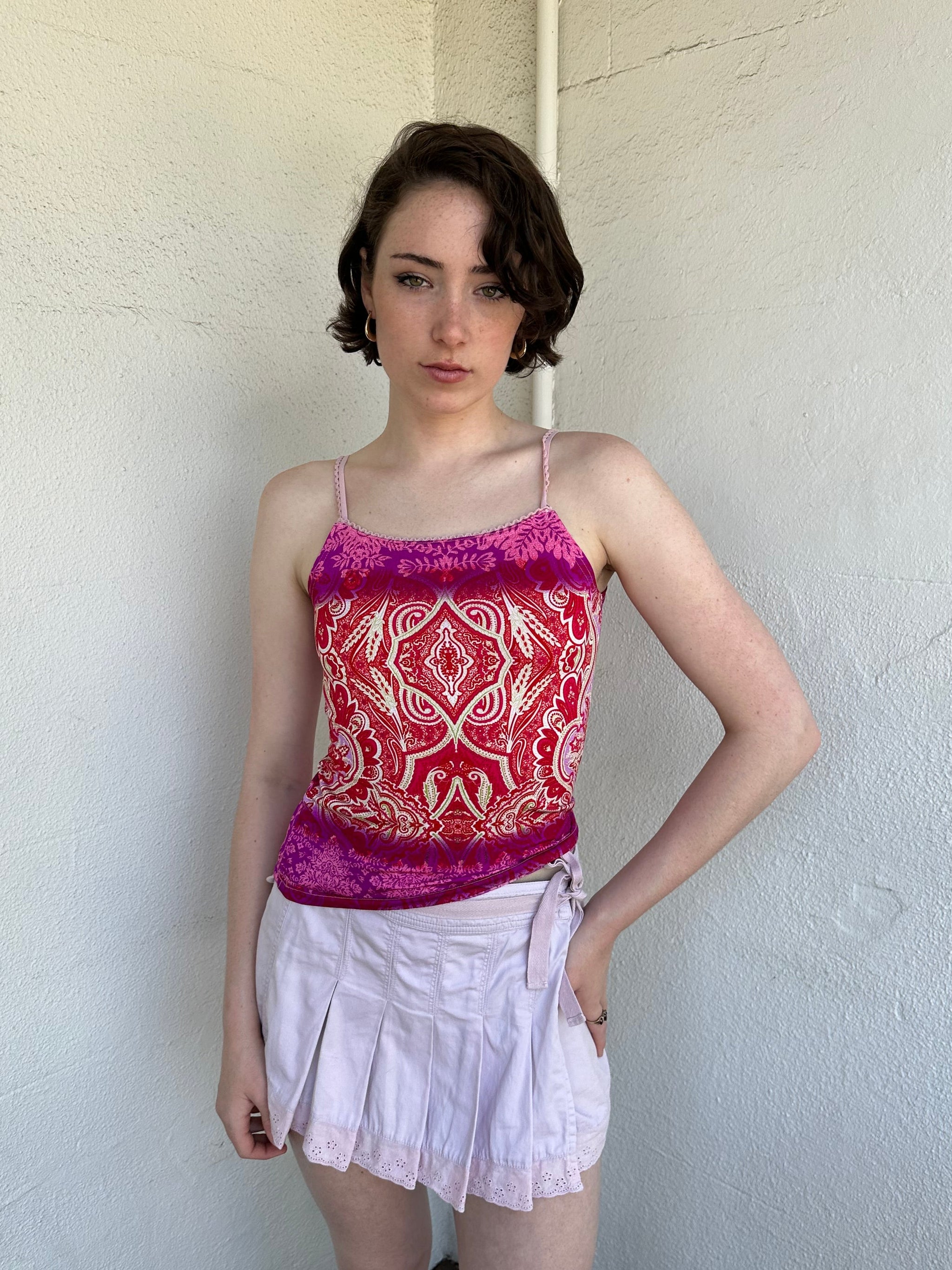 Woman Dressed in Y2K Pink and red patterned cami top featuring a red, pink, and cream mixed paisley and floral-style pattern.