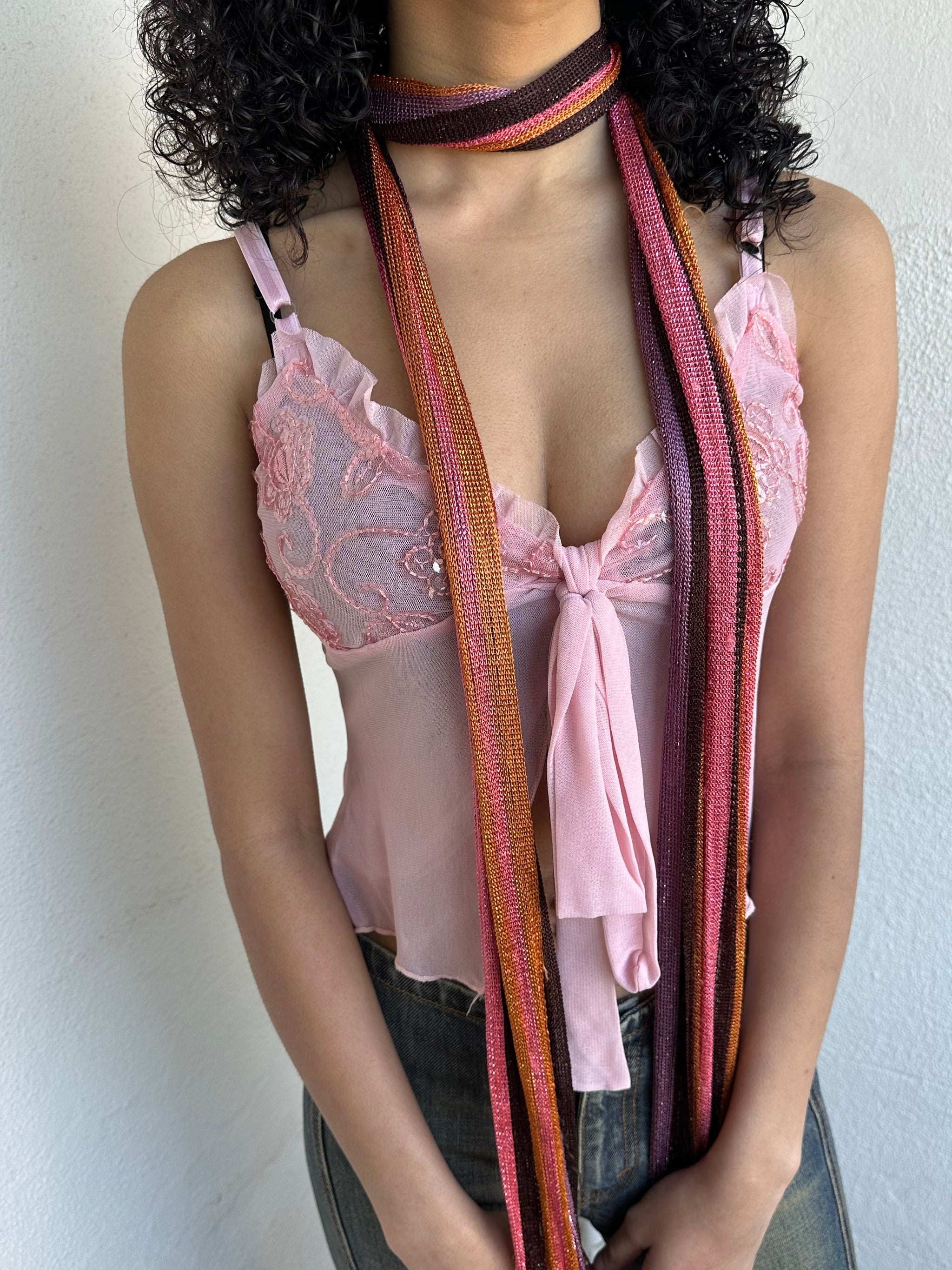 Woman wearing a Y2K 00s Hot pink, orange & lilac stripe shimmer skinny scarf from the 00s.