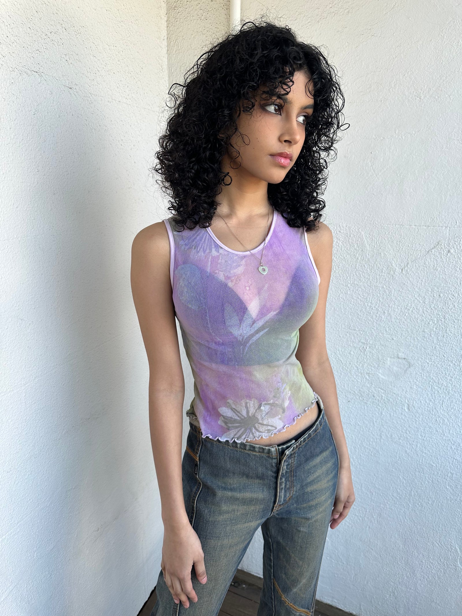 Woman Dressed in Y2K Purple and green flower print mesh tank that’s fully sheer with a soft, lightweight feel. 