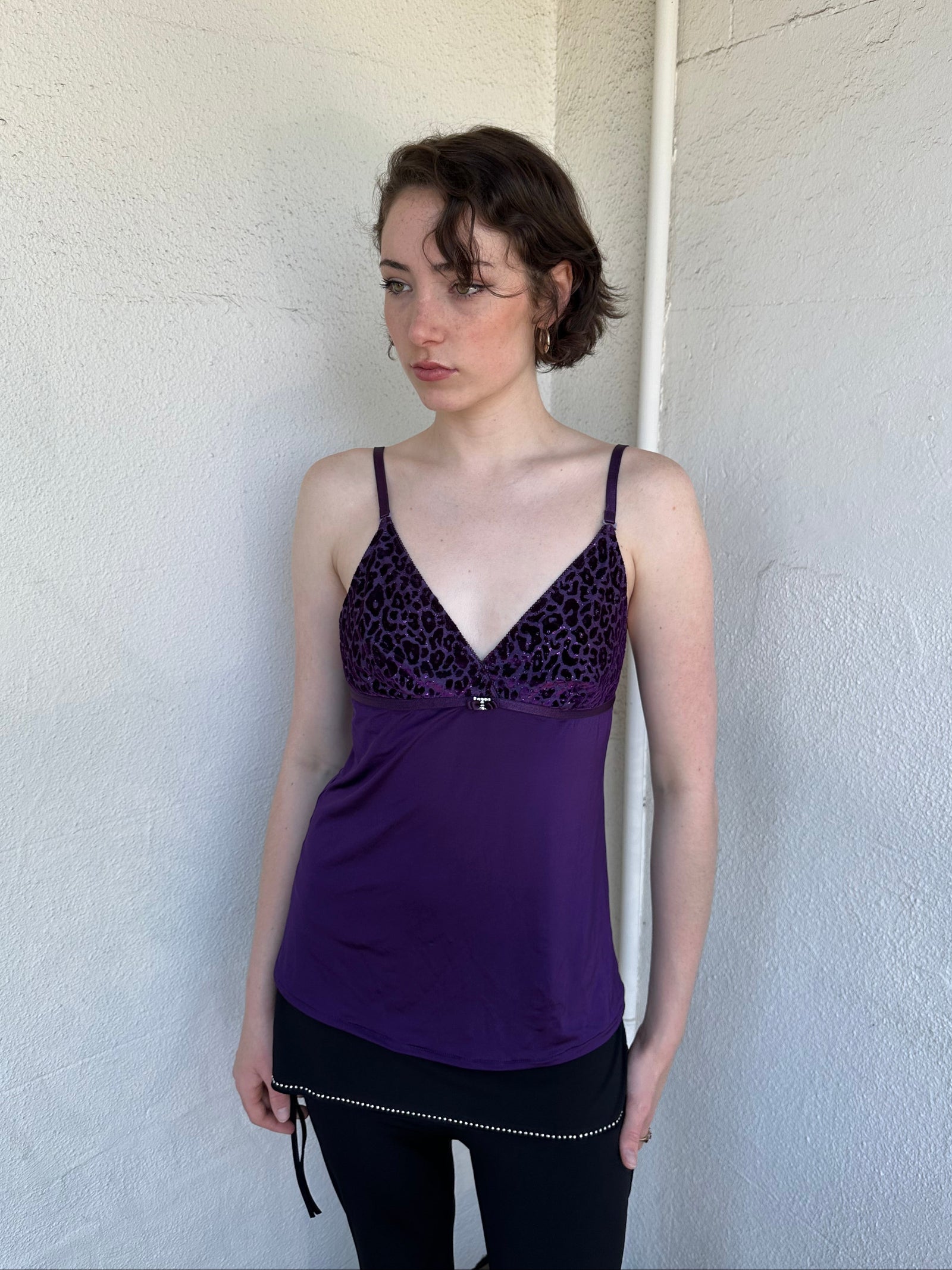 Woman Dressed in Y2K Purple Y2K leopard print cami top featuring a bold sparkly animal print bust.