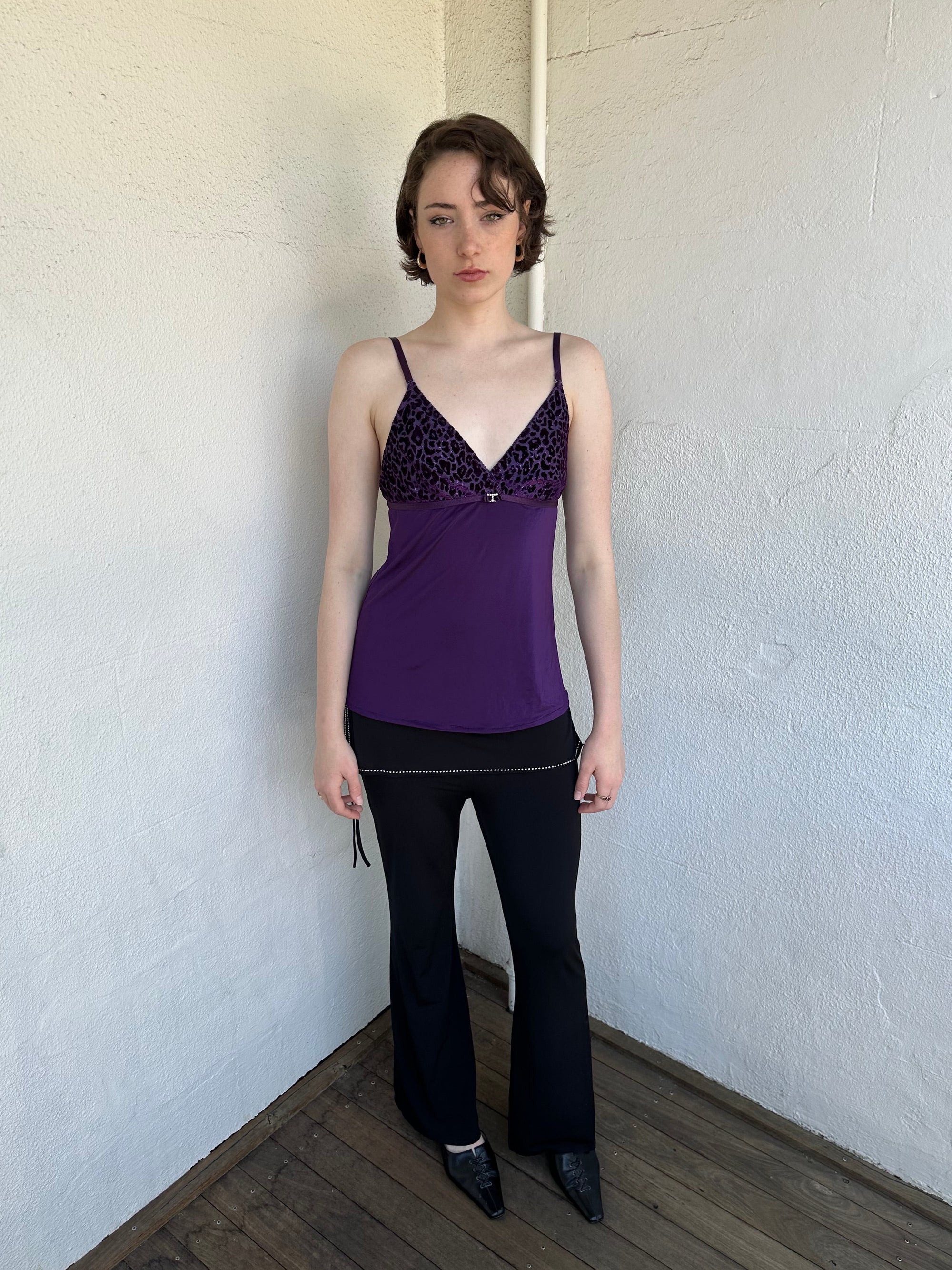 Woman Dressed in Y2K Purple Y2K leopard print cami top featuring a bold sparkly animal print bust.
