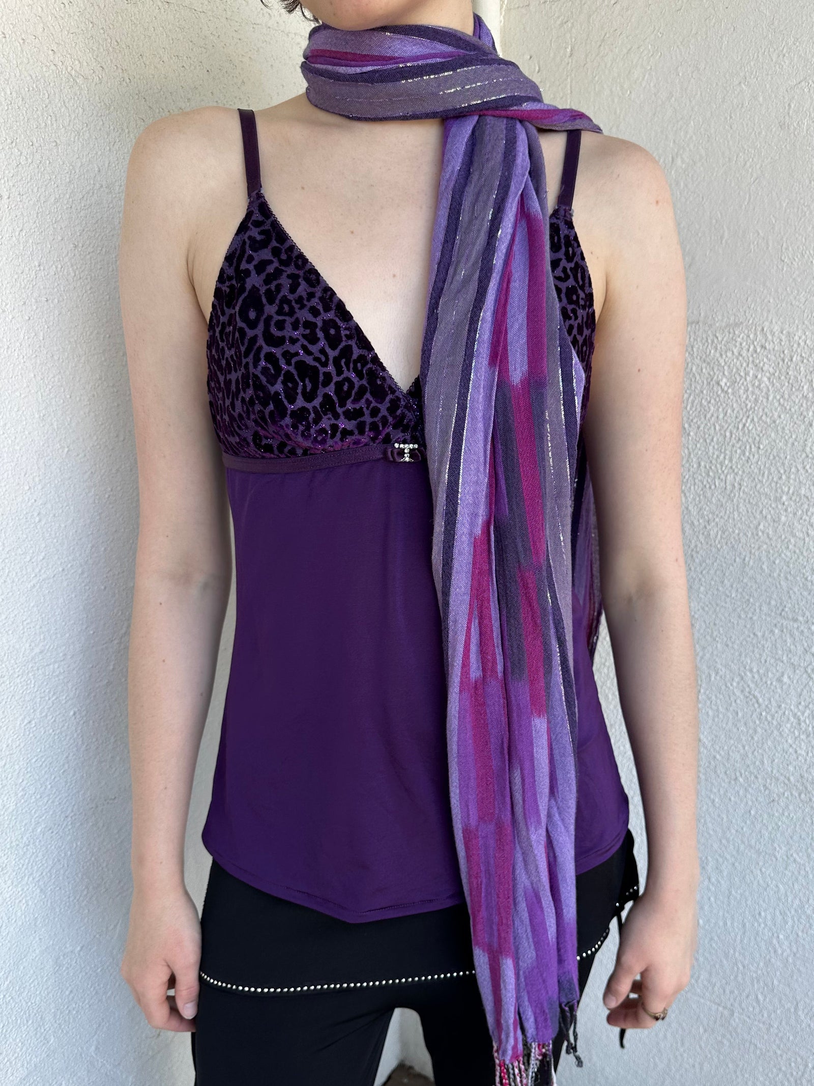 Woman Dressed in Y2K Purple striped festival scarf featuring a striking linear pattern with bold purple tones & flex of silver.