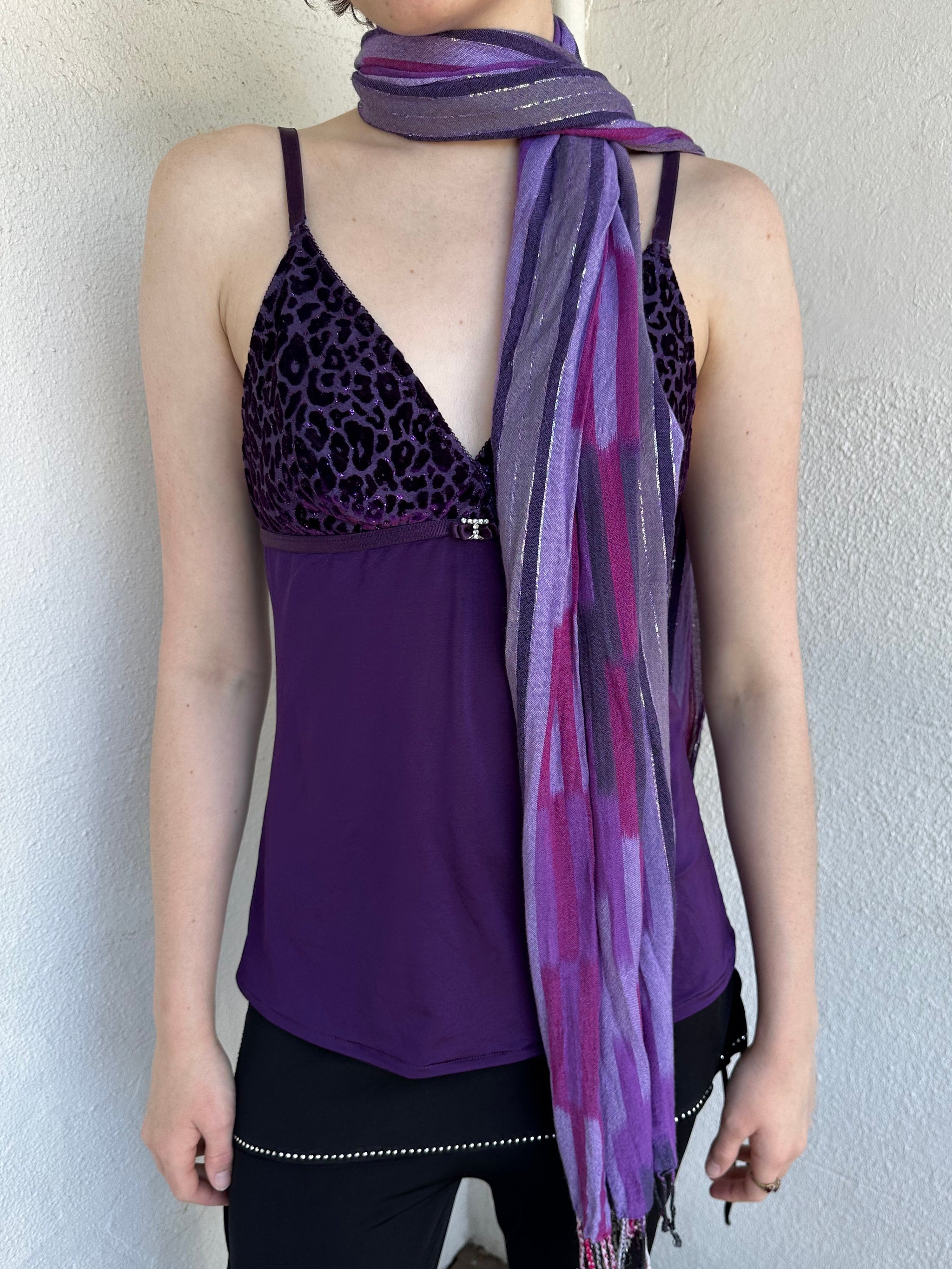 Woman Dressed in Y2K Purple striped festival scarf featuring a striking linear pattern with bold purple tones & flex of silver.