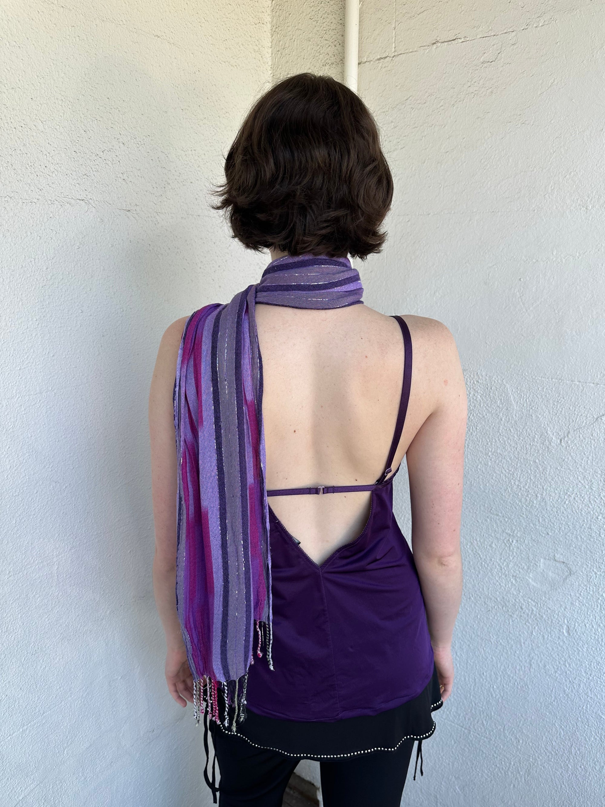 Woman Dressed in Y2K Purple striped festival scarf featuring a striking linear pattern with bold purple tones & flex of silver.