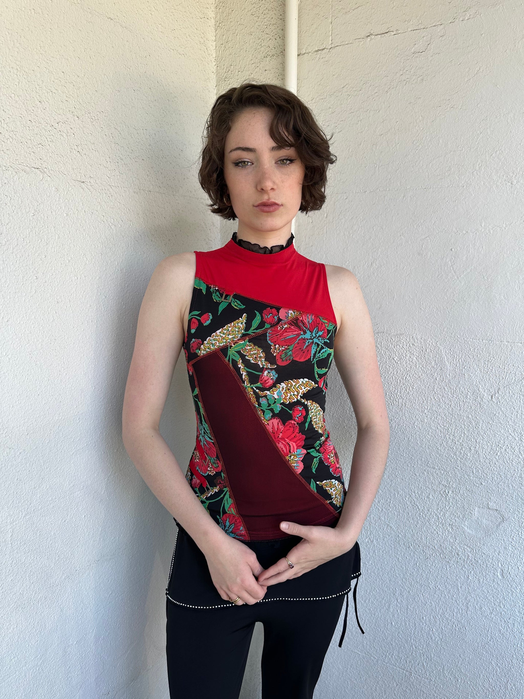 Woman Dressed in Y2K Red and black patchwork floral top featuring a mixed floral patchwork design in red and black tones with silver square ring detailing throughout.