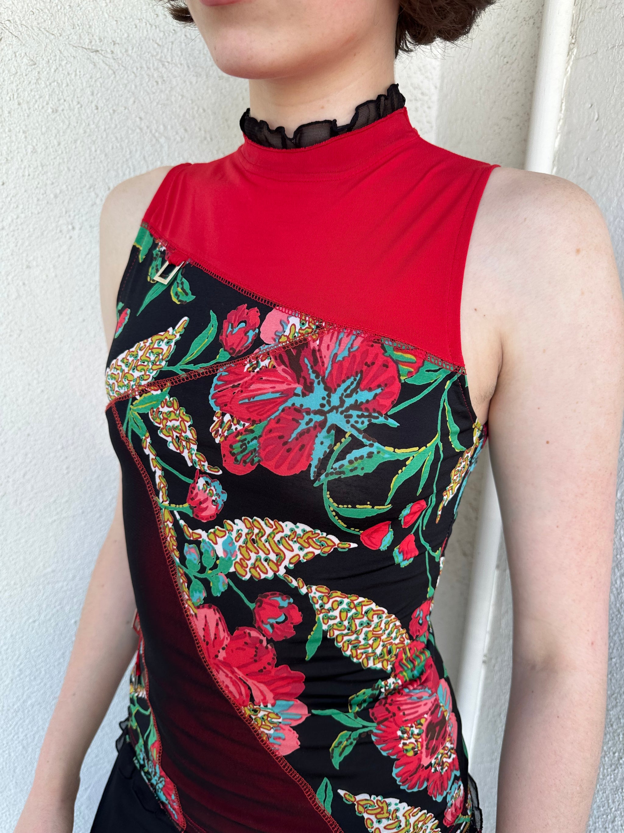 Woman Dressed in Y2K Red and black patchwork floral top featuring a mixed floral patchwork design in red and black tones with silver square ring detailing throughout.