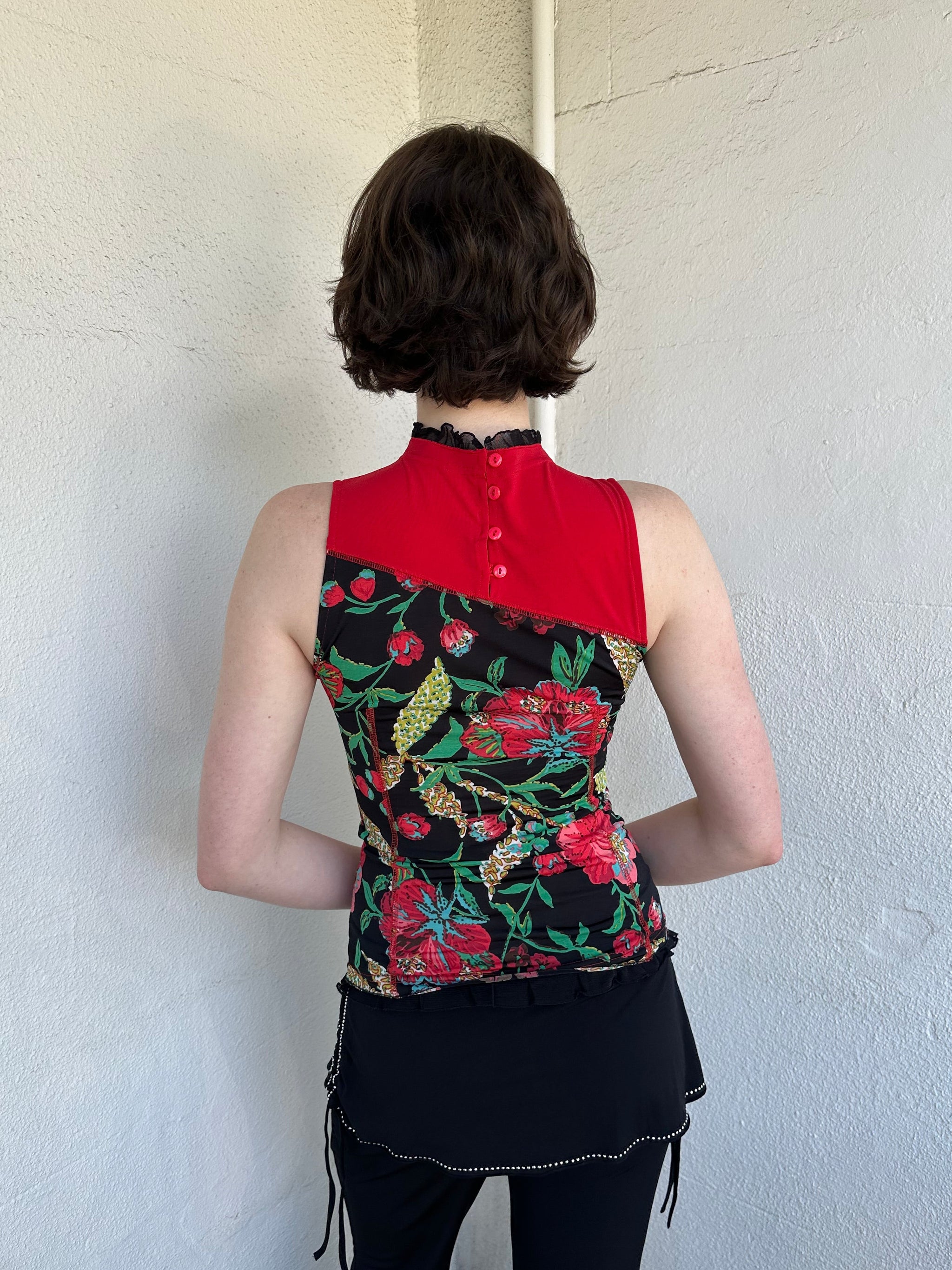 Woman Dressed in Y2K Red and black patchwork floral top featuring a mixed floral patchwork design in red and black tones with silver square ring detailing throughout.