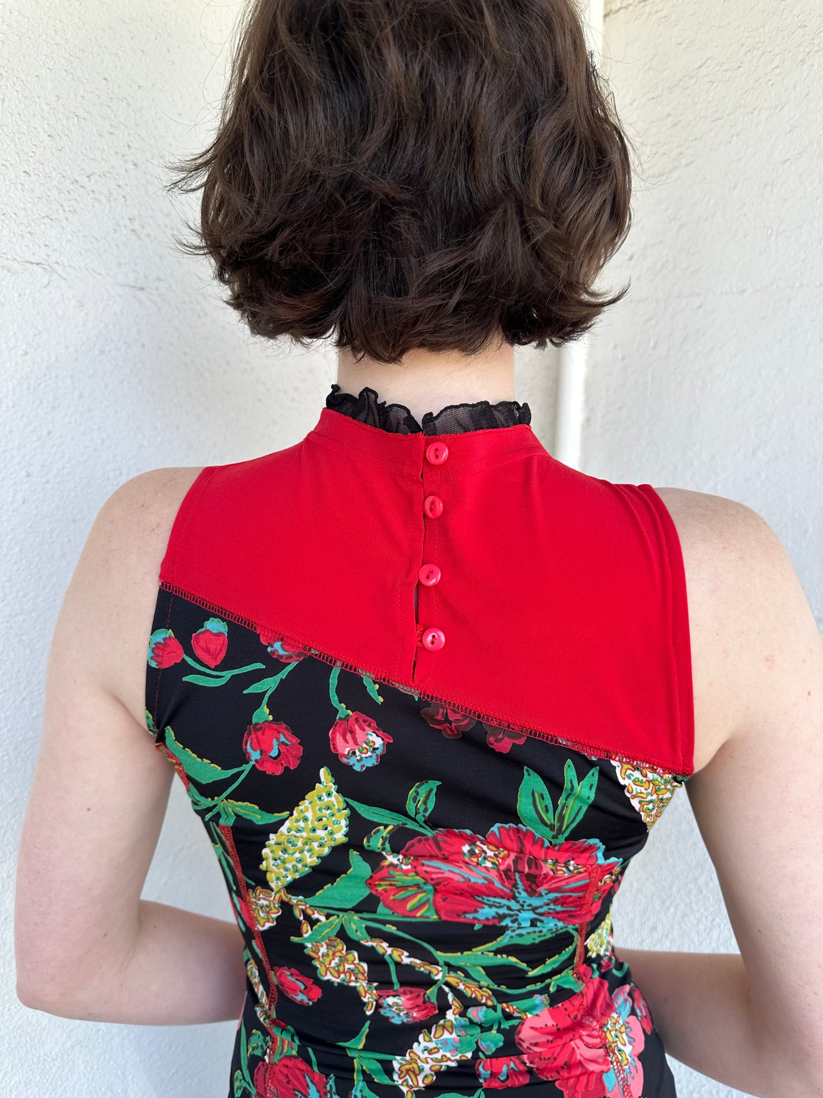 Woman Dressed in Y2K Red and black patchwork floral top featuring a mixed floral patchwork design in red and black tones with silver square ring detailing throughout.