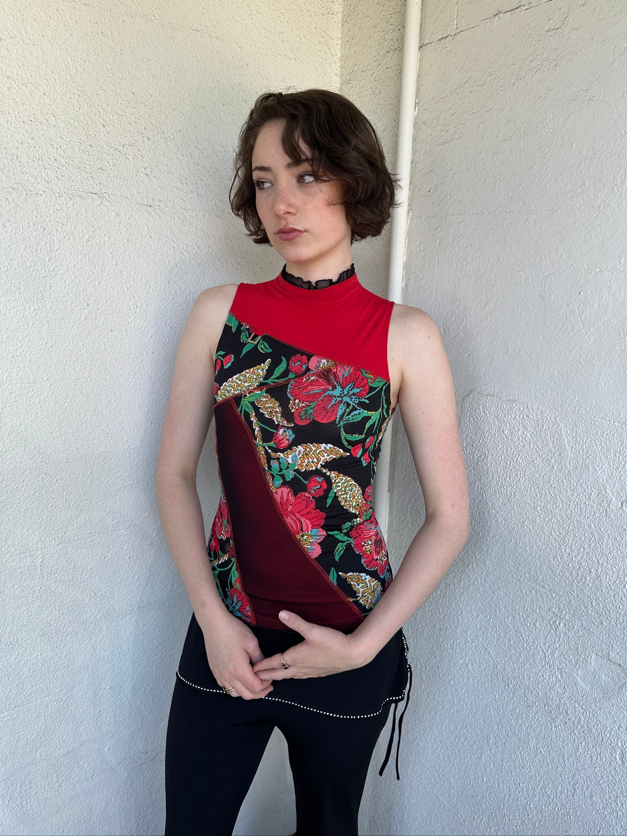 Woman Dressed in Y2K Red and black patchwork floral top featuring a mixed floral patchwork design in red and black tones with silver square ring detailing throughout.