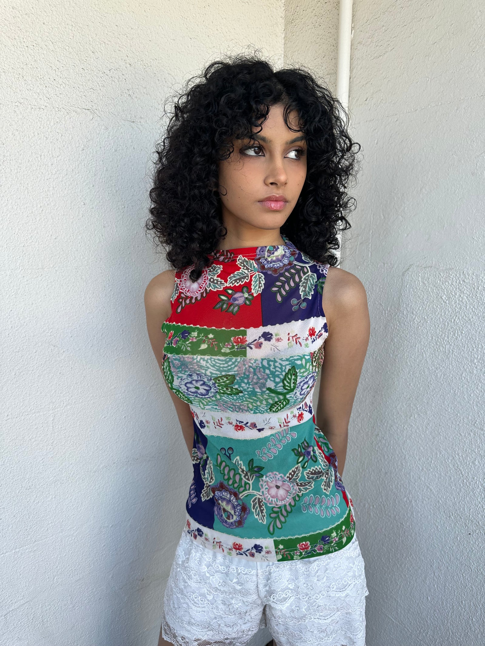 Women wearing a 00s Y2K Red, green, white and blue floral patchwork tank top in a sleeveless high-neck mesh design. 