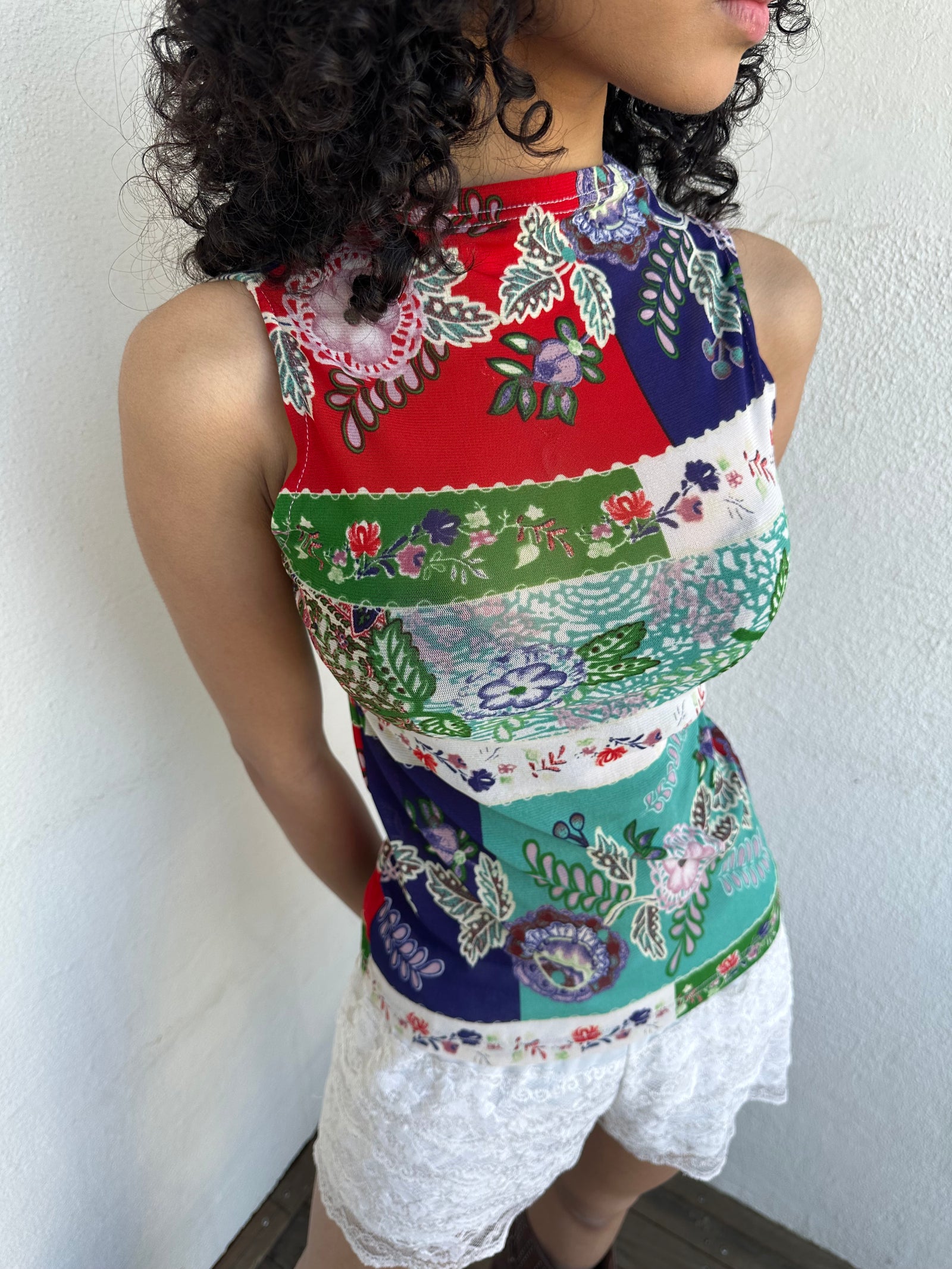 Women wearing a 00s Y2K Red, green, white and blue floral patchwork tank top in a sleeveless high-neck mesh design. 