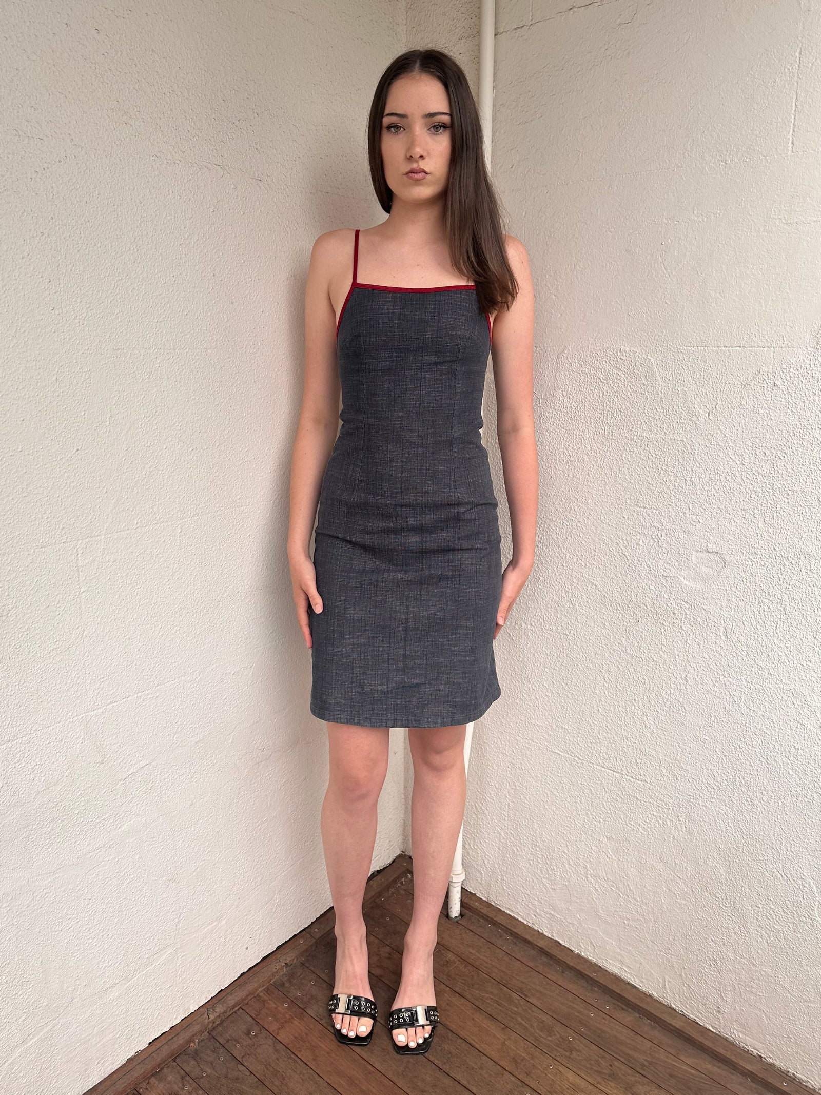 Woman wearing a Y2K 00s Red trimmed dark denim midi dress with a fitted elegant cut.