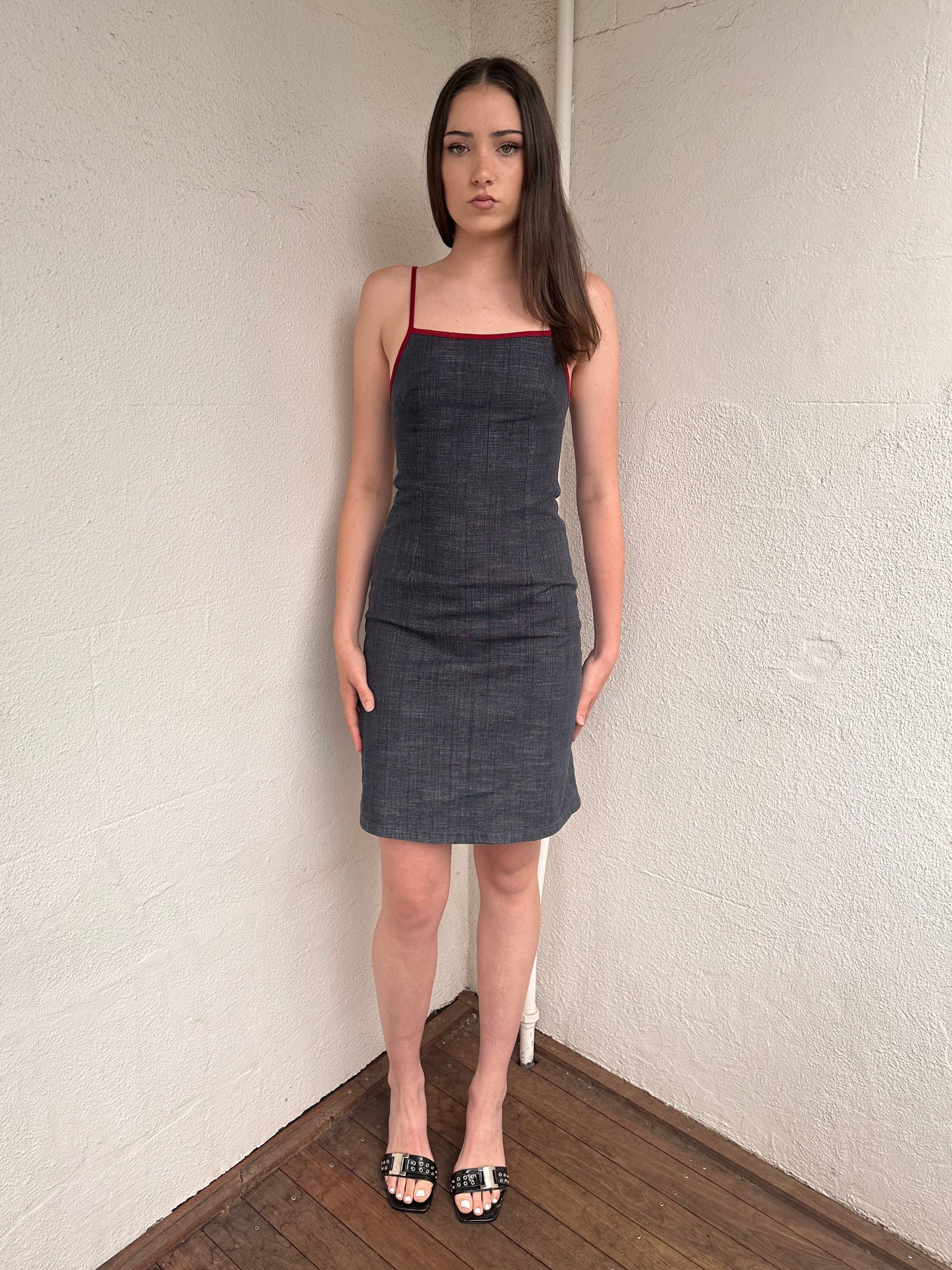 Woman wearing a Y2K 00s Red trimmed dark denim midi dress with a fitted elegant cut.