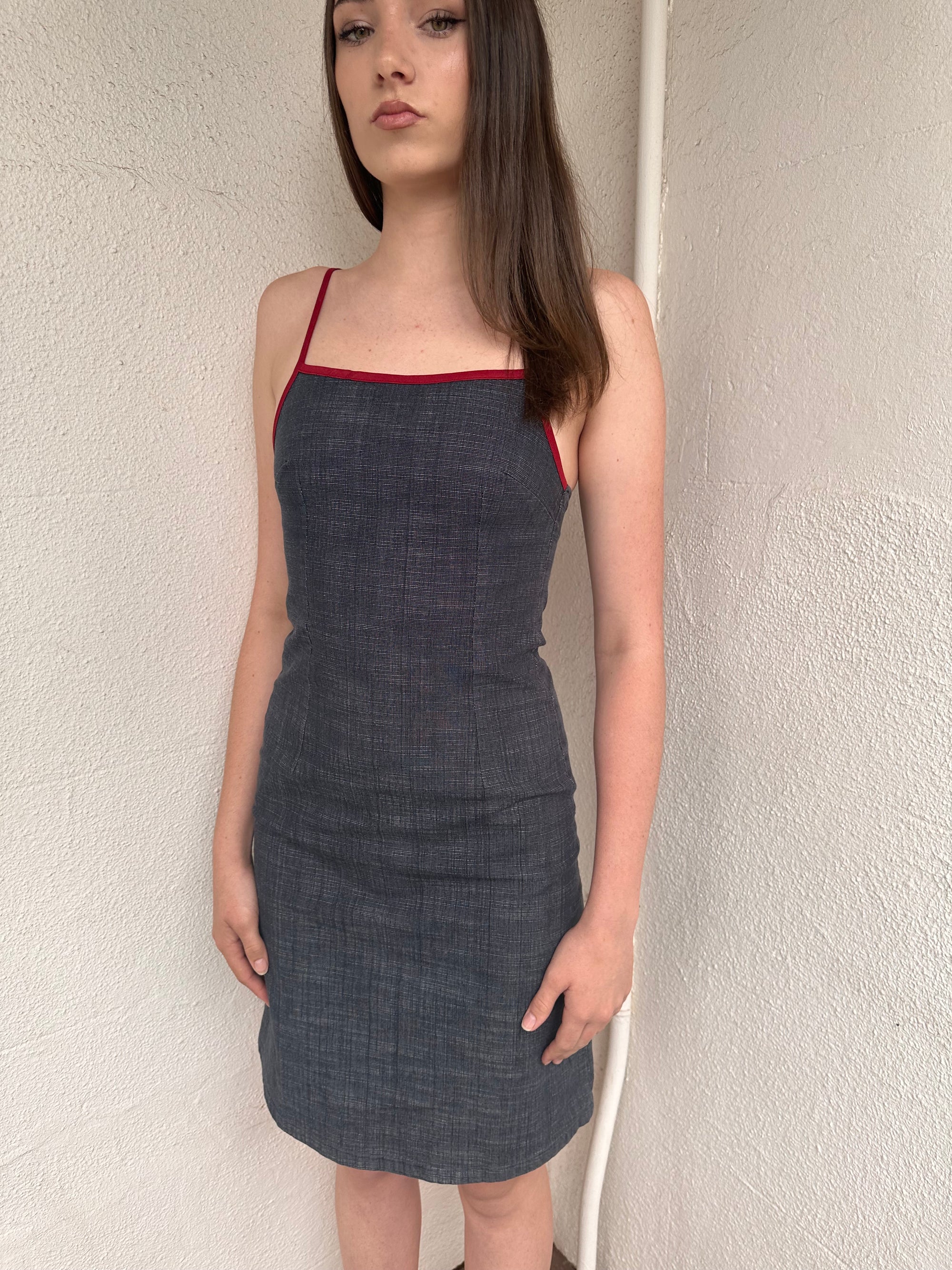 Woman wearing a Y2K 00s Red trimmed dark denim midi dress with a fitted elegant cut.