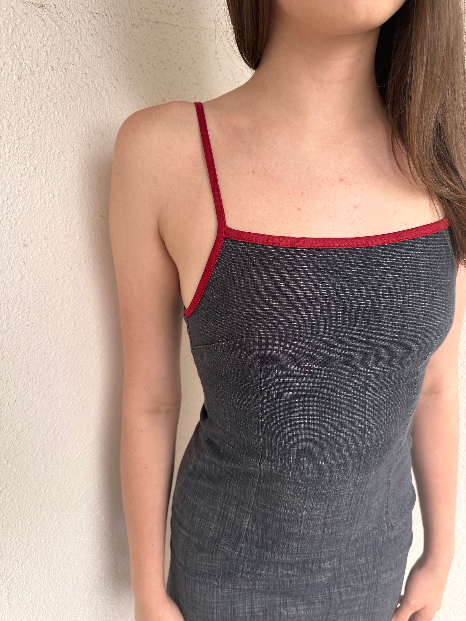 Woman wearing a Y2K 00s Red trimmed dark denim midi dress with a fitted elegant cut.