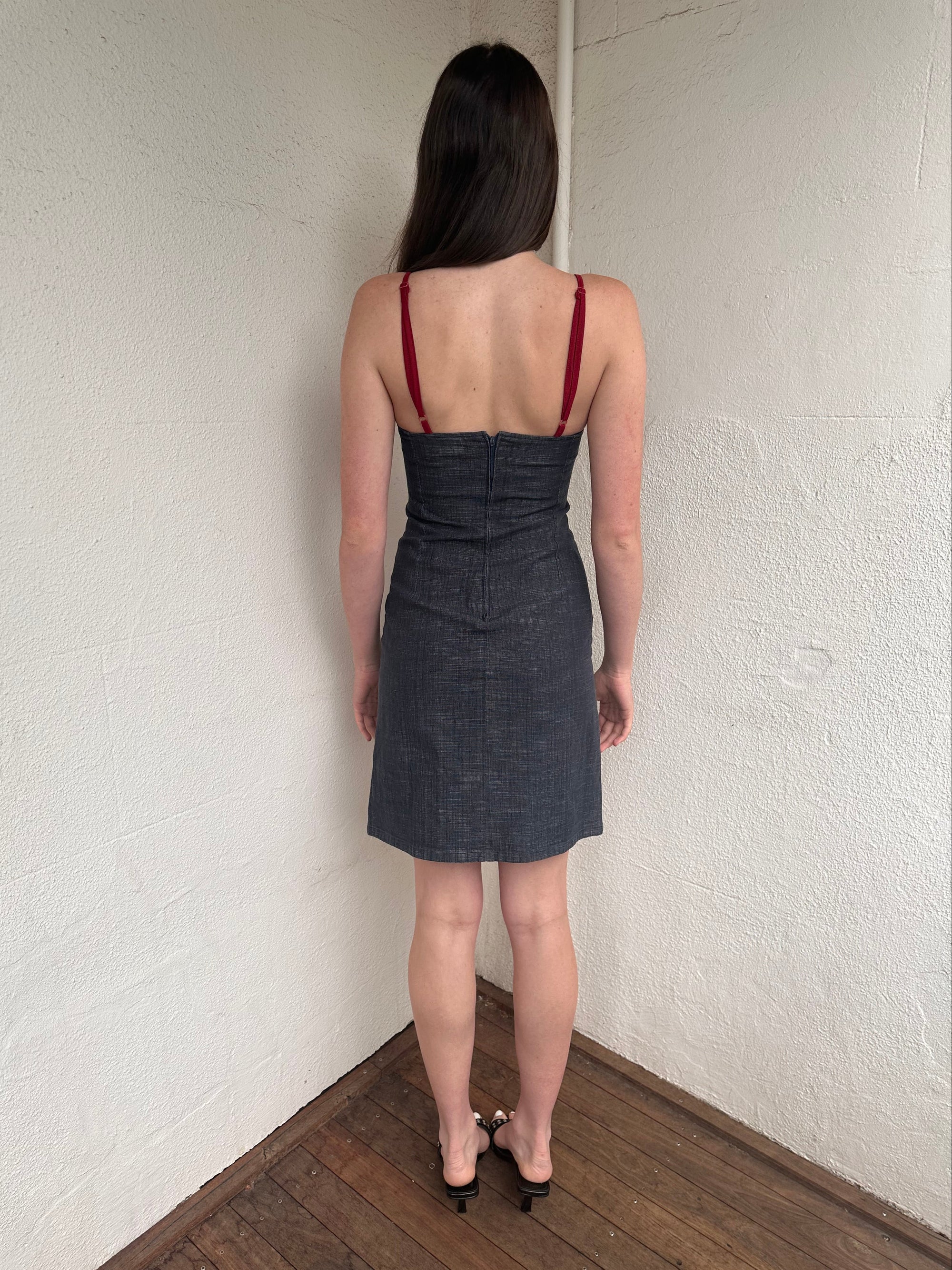 Woman wearing a Y2K 00s Red trimmed dark denim midi dress with a fitted elegant cut.