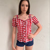 Women wearing a 00s Y2K Red and white checkered blouse with an off-the-shoulder design and chunky buckle straps. 