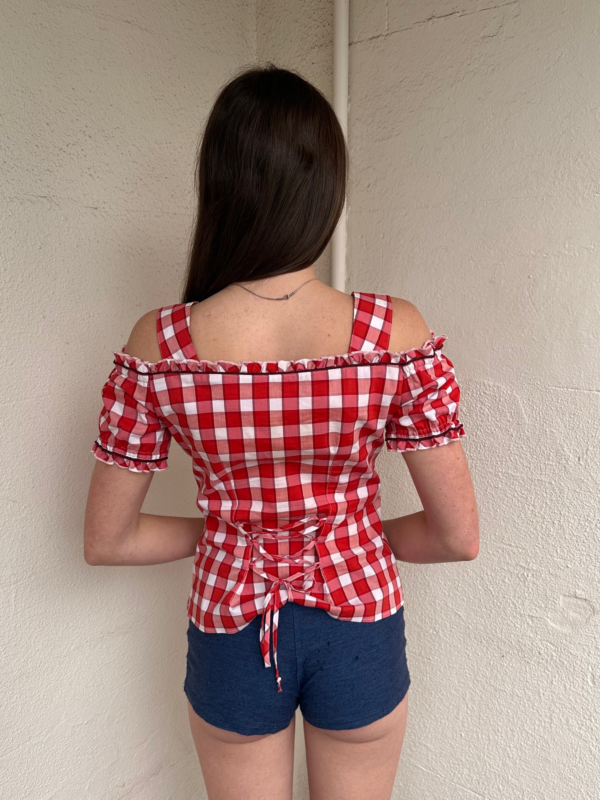Women wearing a 00s Y2K Red and white checkered blouse with an off-the-shoulder design and chunky buckle straps. 