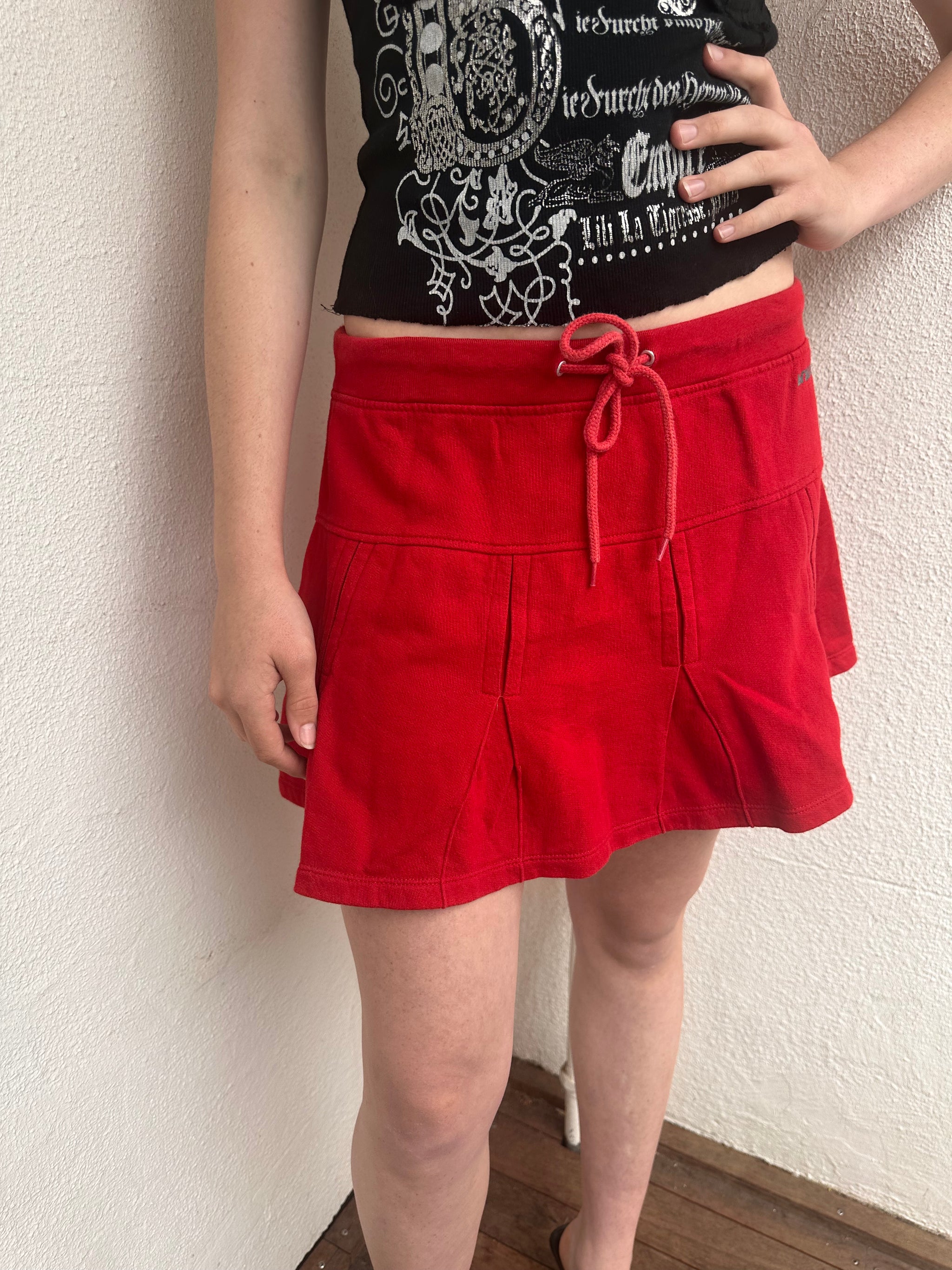 Woman wearing a Y2K 00s Red Drawstring Pleated Mini Skirt