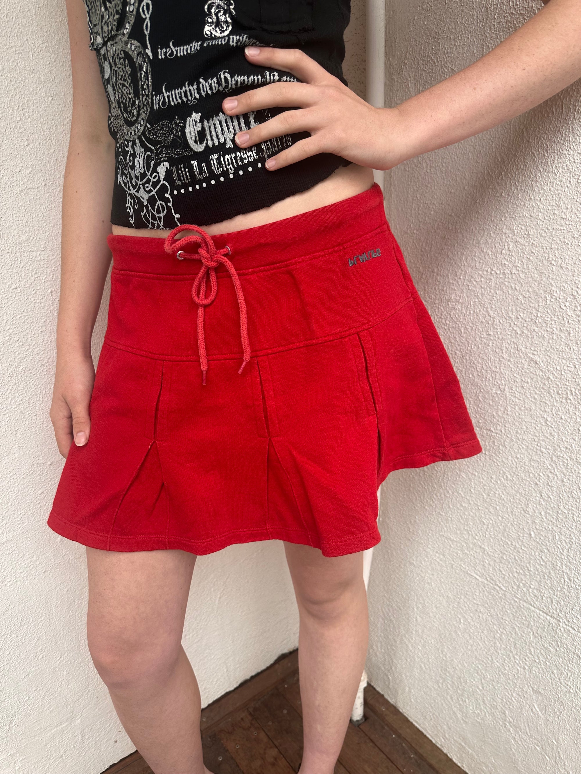 Woman wearing a Y2K 00s Red Drawstring Pleated Mini Skirt