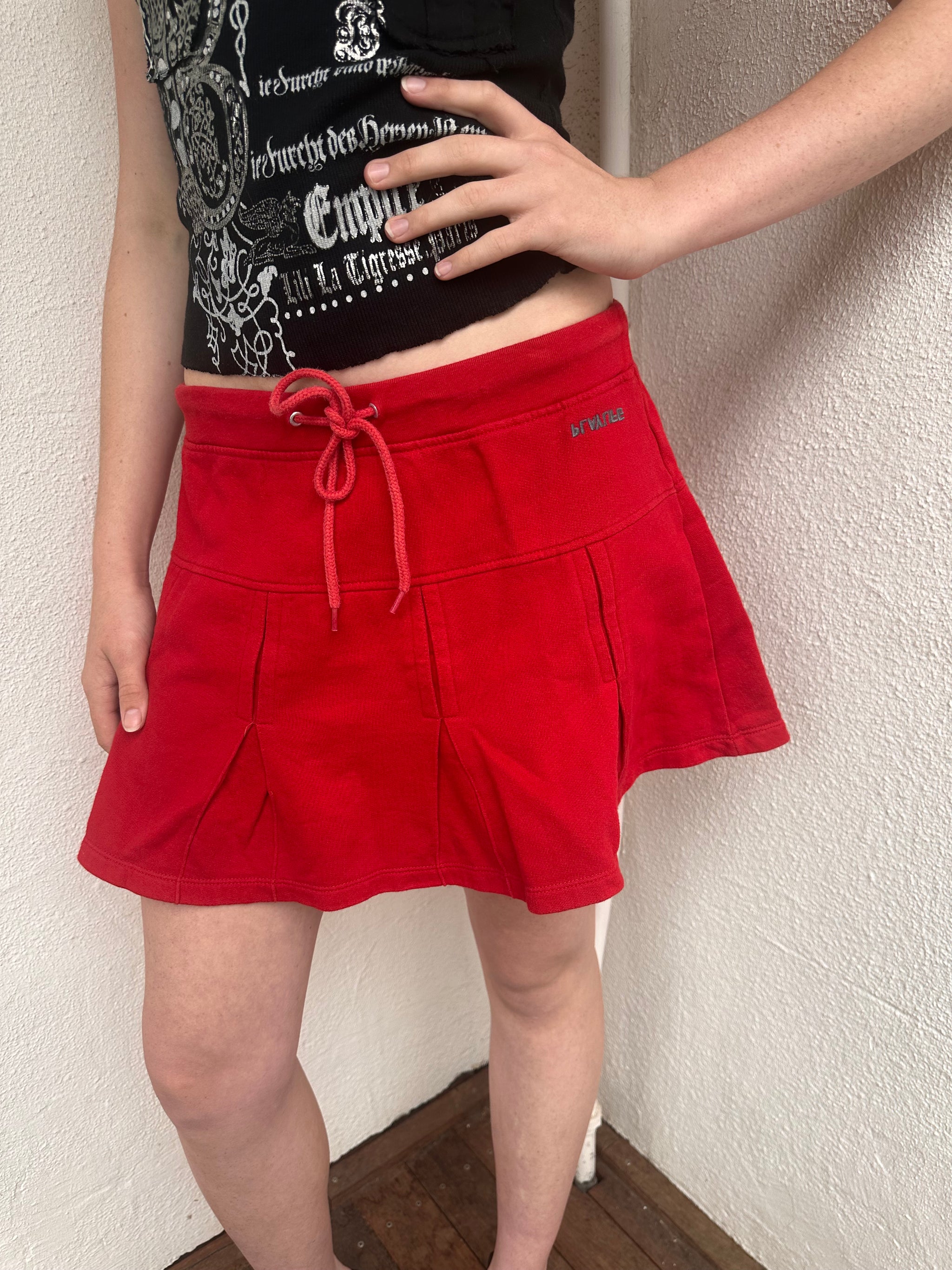 Woman wearing a Y2K 00s Red Drawstring Pleated Mini Skirt