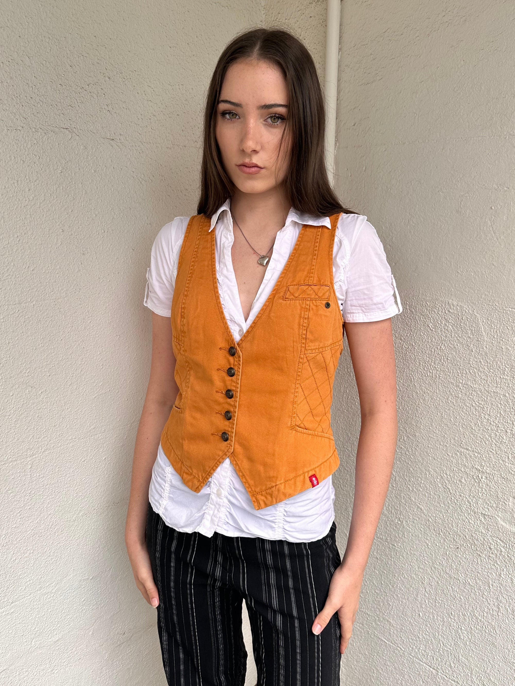 Woman wearing a Y2K 00s Rusty orange waistcoat with a fitted, tailored shape and stitching detail