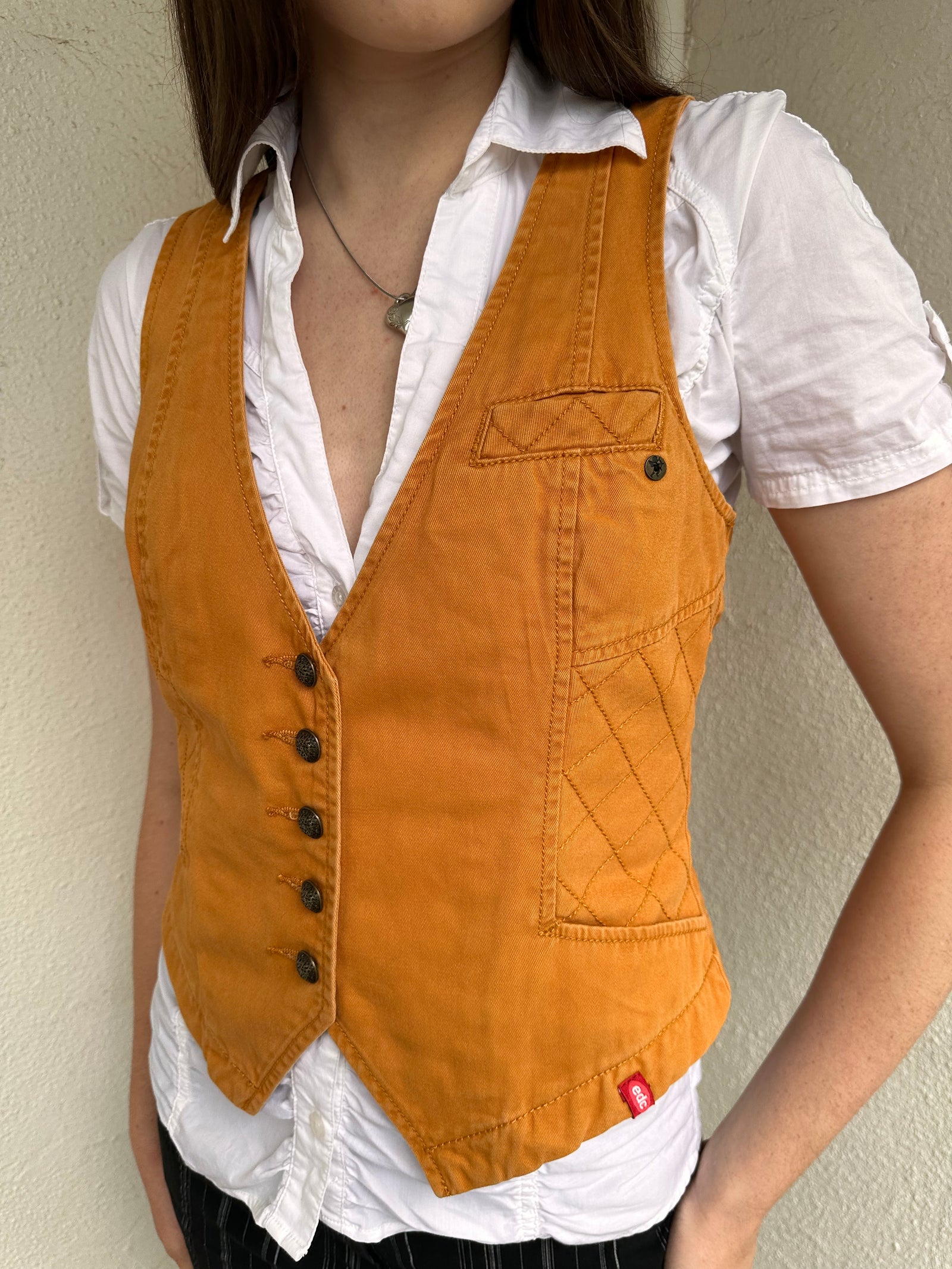 Woman wearing a Y2K 00s Rusty orange waistcoat with a fitted, tailored shape and stitching detail