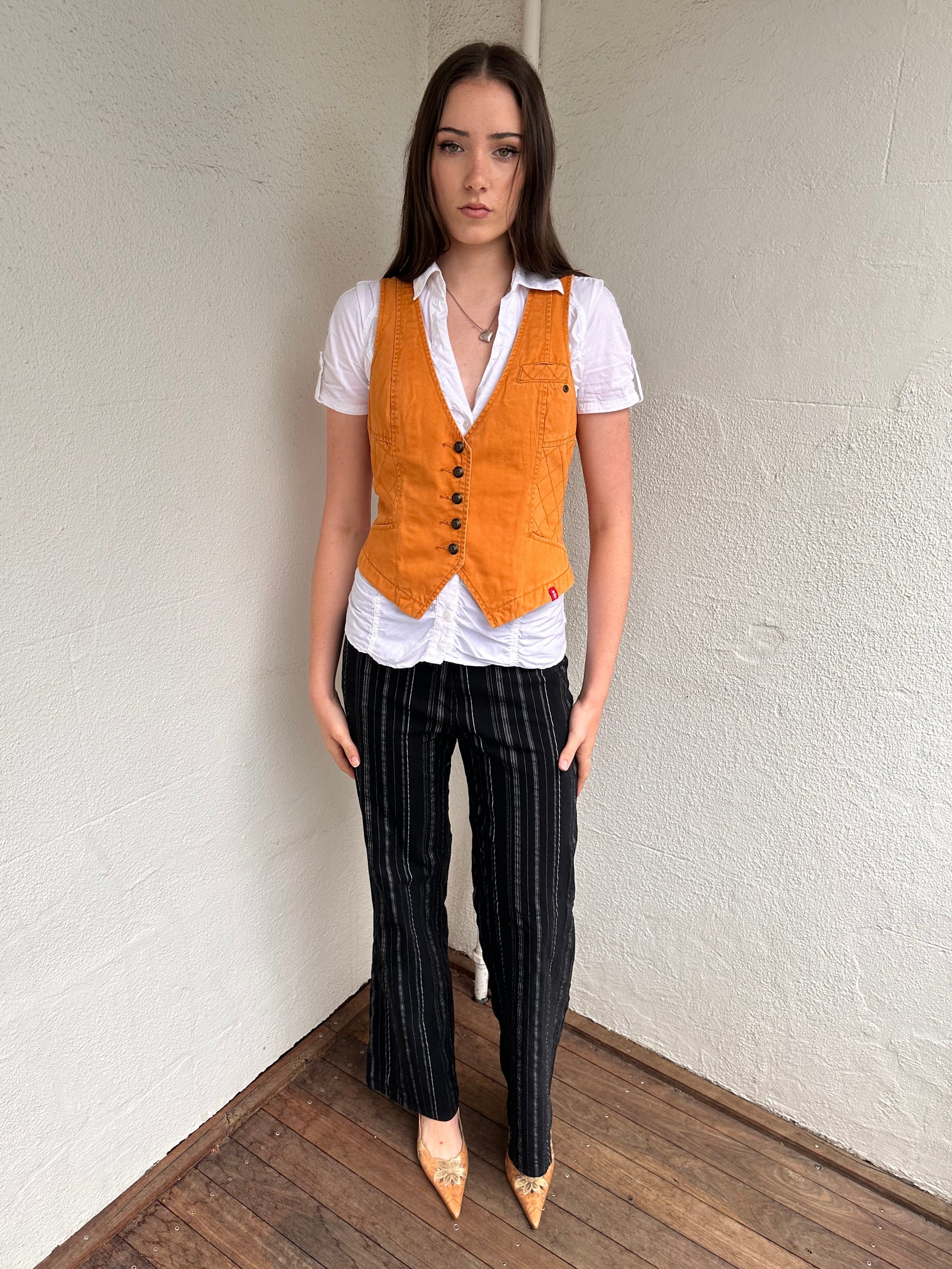 Woman wearing a Y2K 00s Rusty orange waistcoat with a fitted, tailored shape and stitching detail