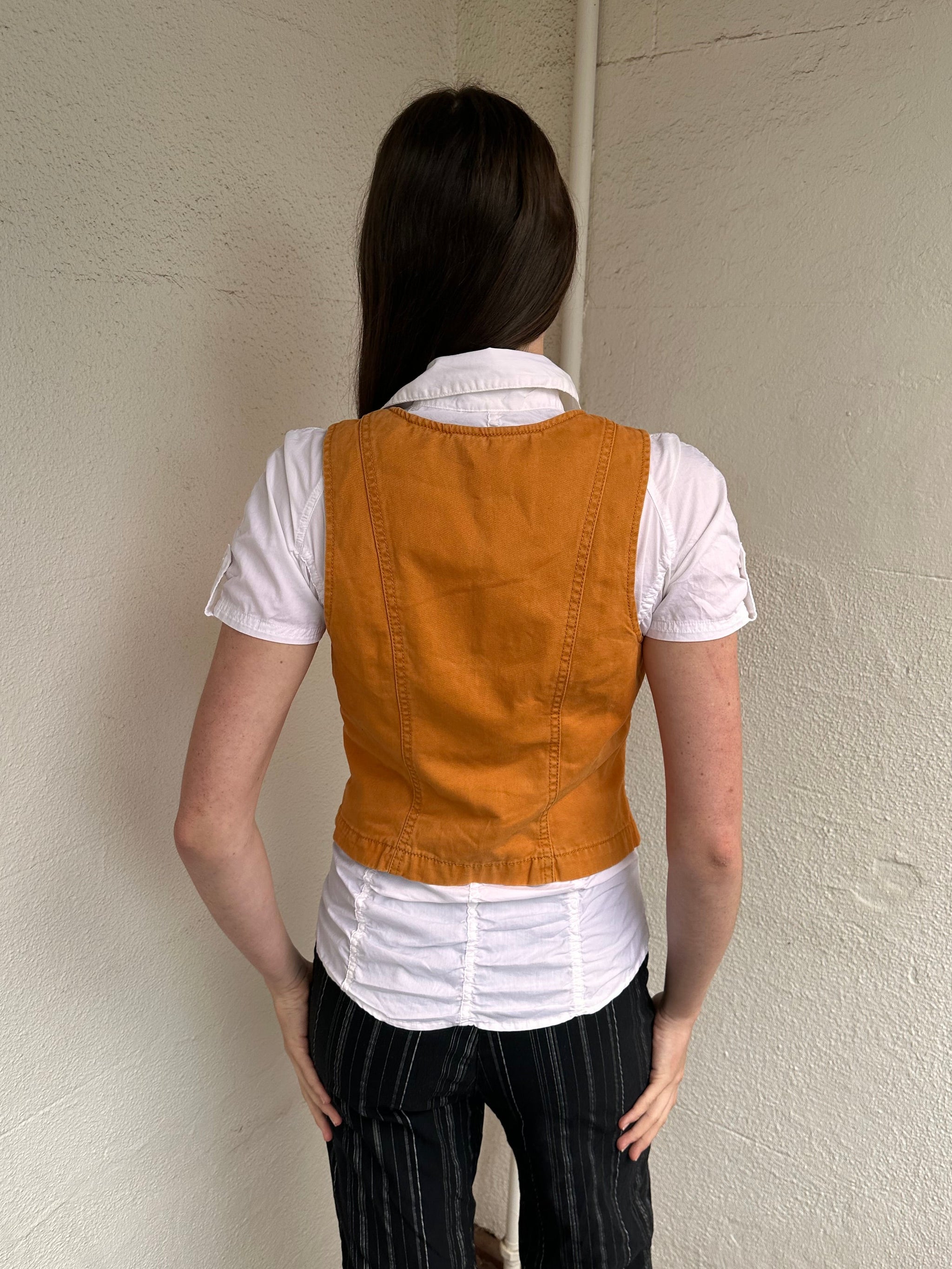 Woman wearing a Y2K 00s Rusty orange waistcoat with a fitted, tailored shape and stitching detail